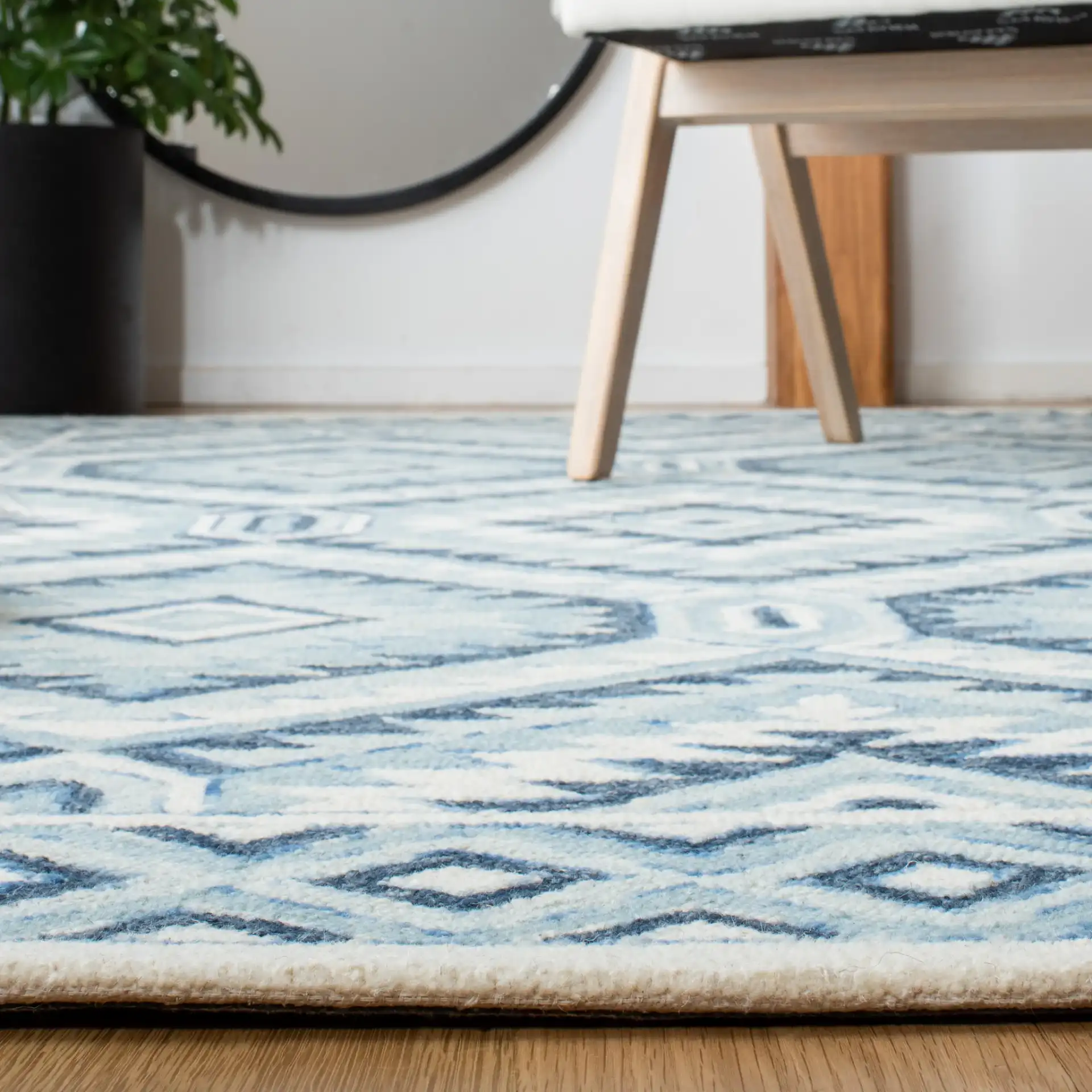 Metro Tribal Serrated Diamond Medallion Hand-Tufted Wool Rug in Blue / Ivory in a styled room