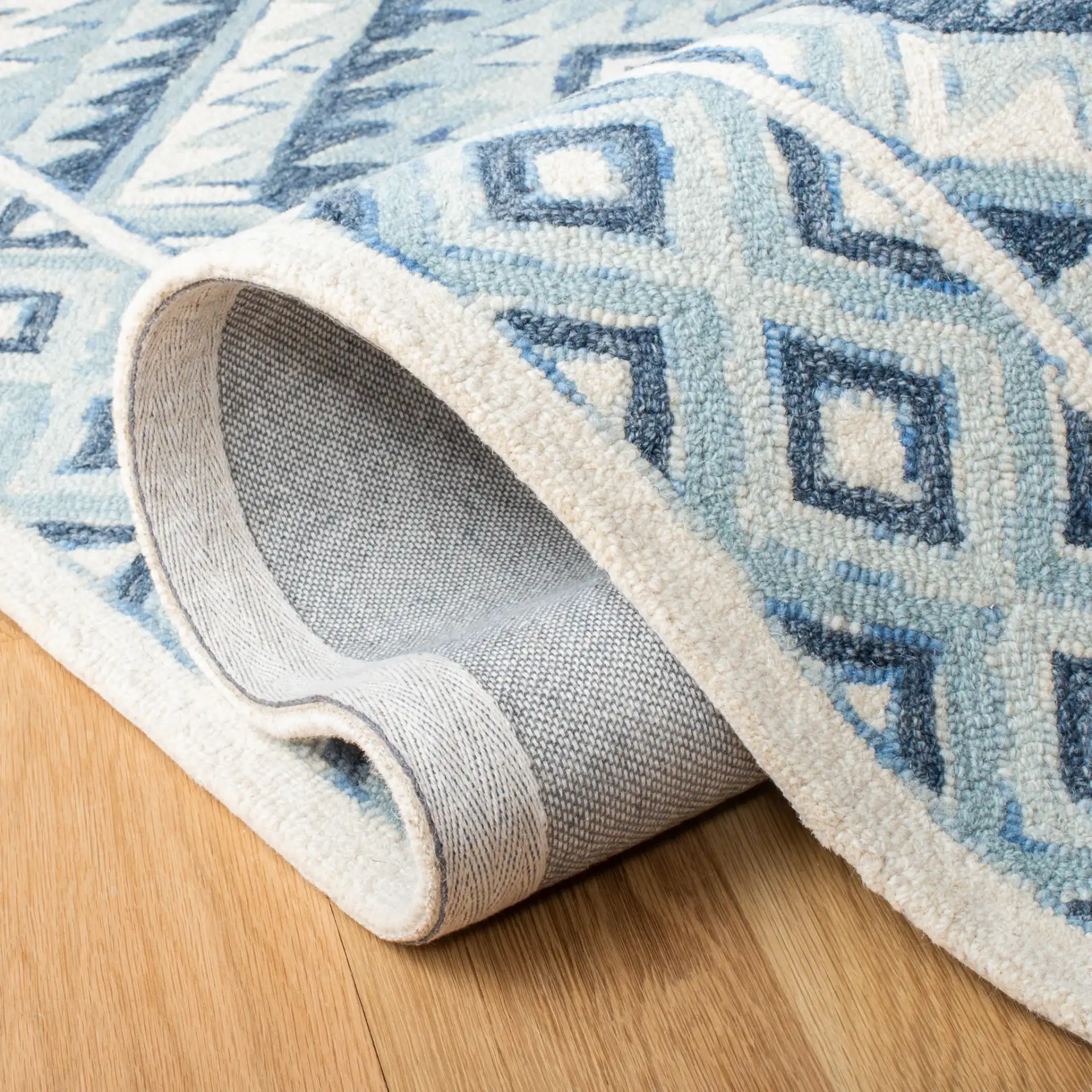 Metro Tribal Serrated Diamond Medallion Hand-Tufted Wool Rug in Blue / Ivory in a styled room