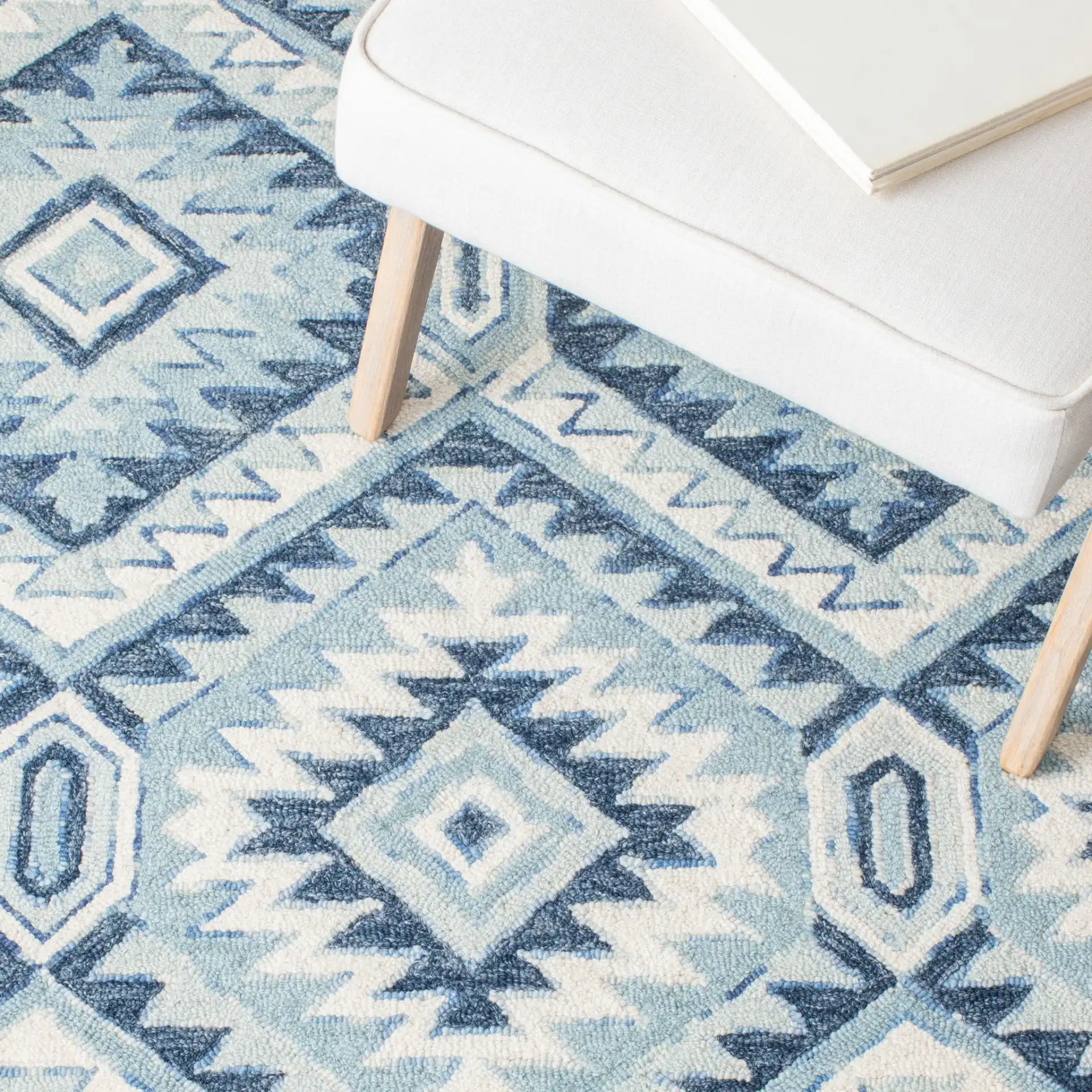 Metro Tribal Serrated Diamond Medallion Hand-Tufted Wool Rug in Blue / Ivory in a styled room