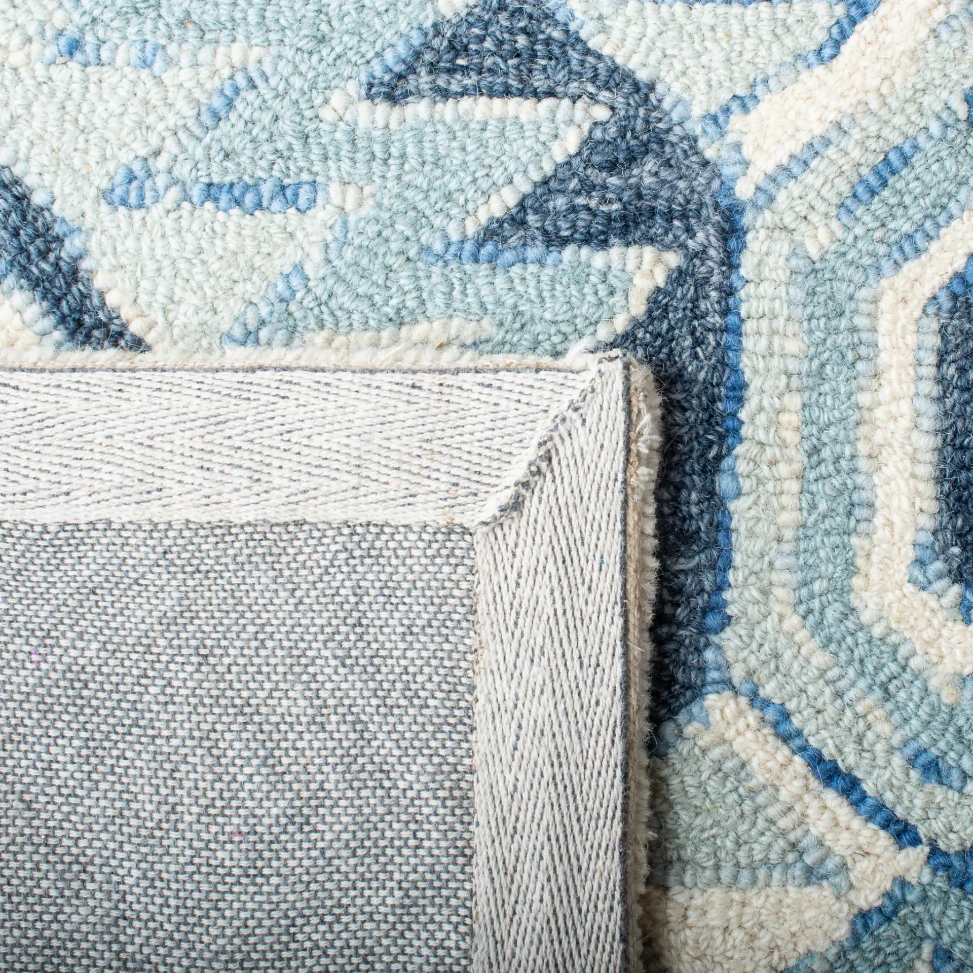 Metro Tribal Serrated Diamond Medallion Hand-Tufted Wool Rug in Blue / Ivory in a styled room