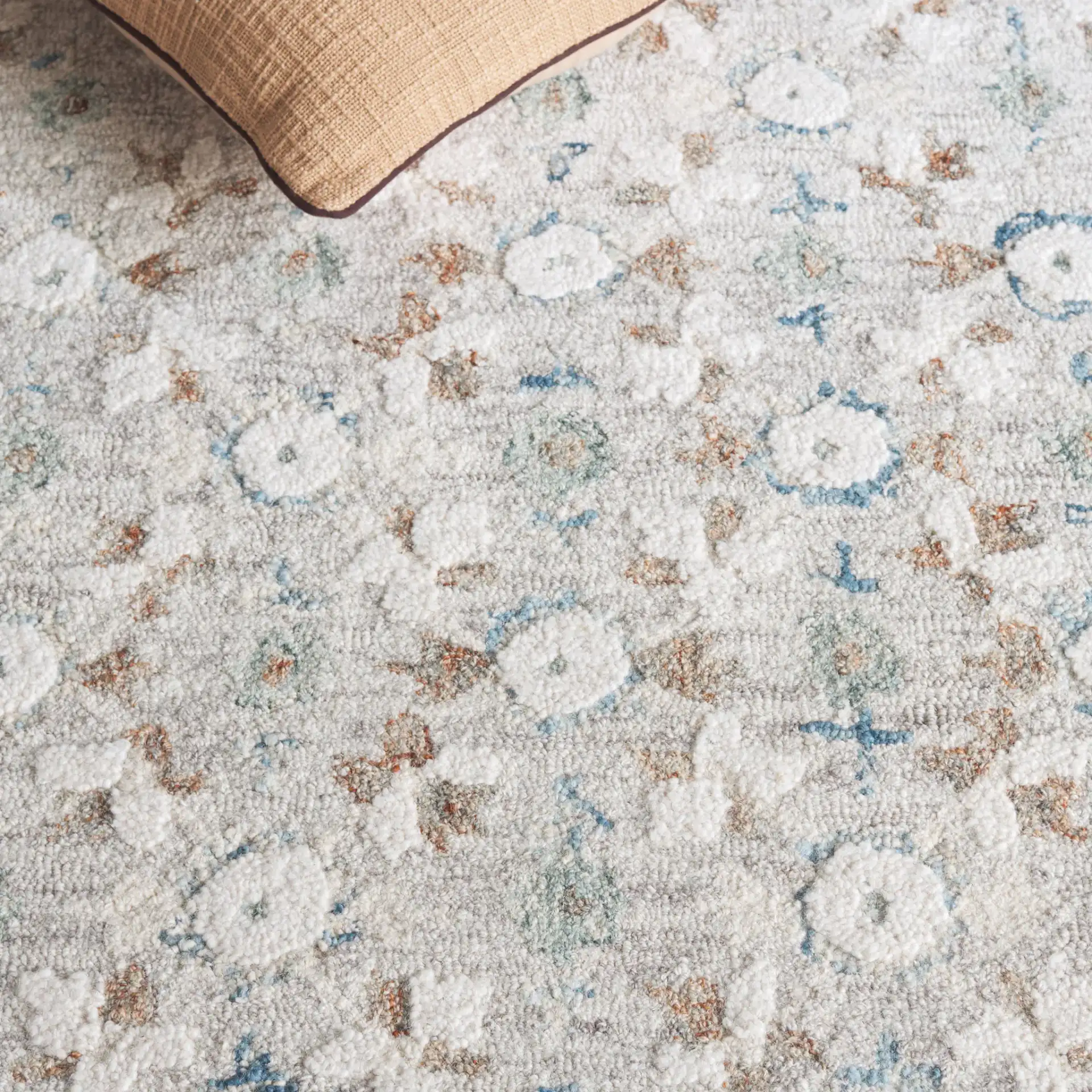 Metro Rosette Bordered Hand-Tufted Wool Rug in Ivory / Blue in a styled room