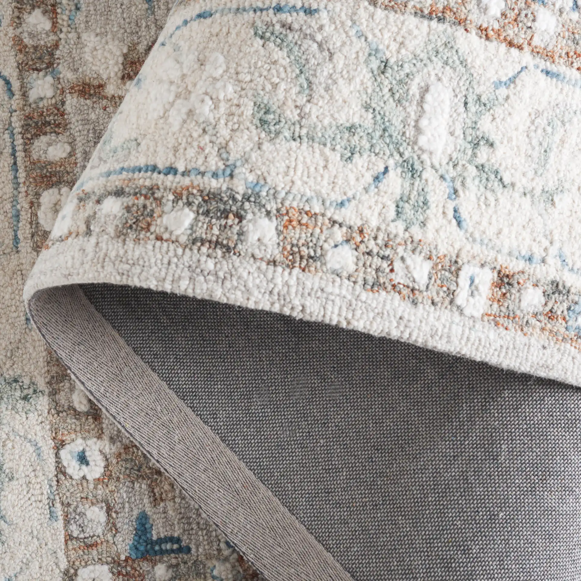 Metro Rosette Bordered Hand-Tufted Wool Rug in Ivory / Blue in a styled room