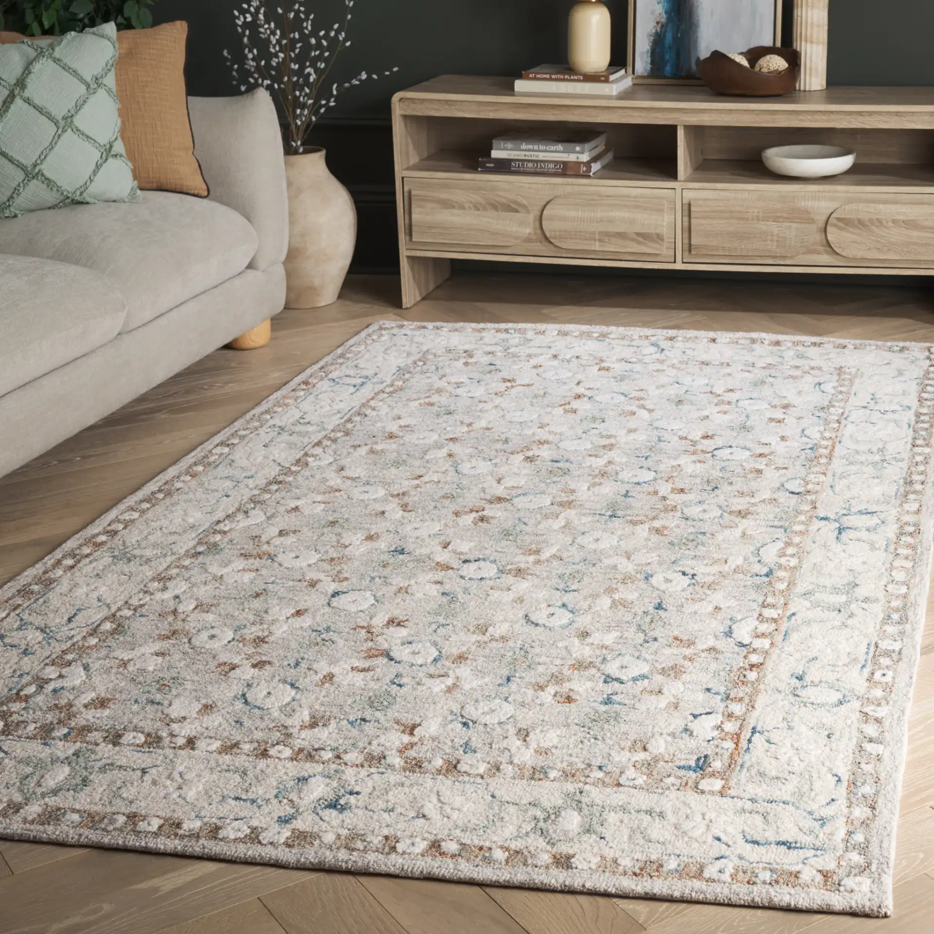 Metro Rosette Bordered Hand-Tufted Wool Rug in Ivory / Blue in a styled room