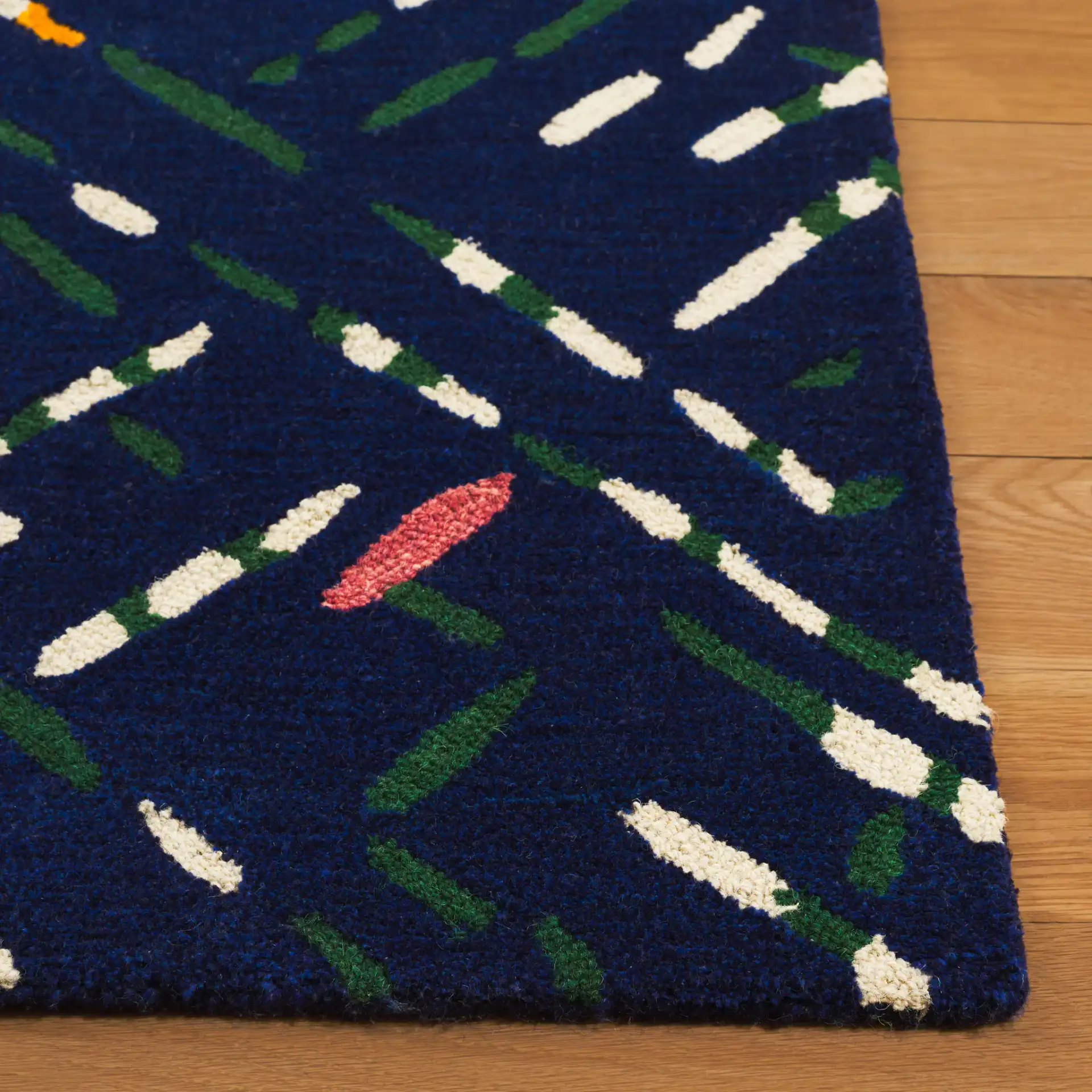 Metro Abstract Dash Hand-Tufted Wool Rug in Navy / Pink in a styled room