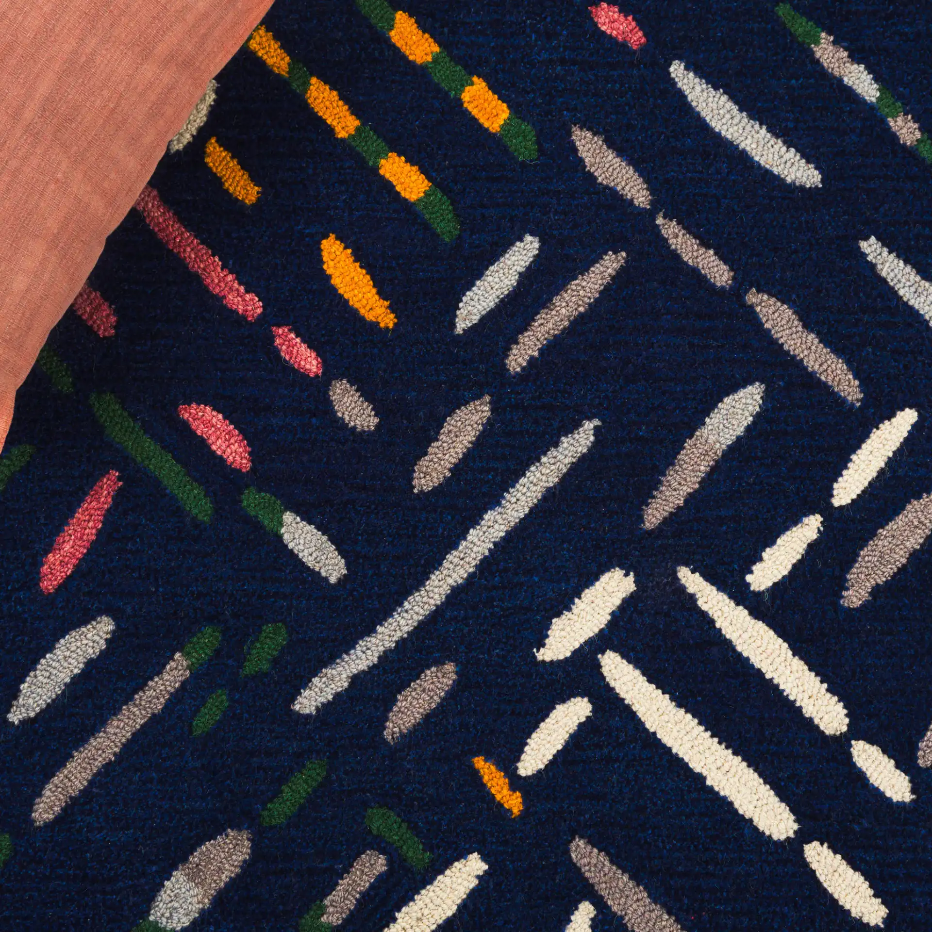 Metro Abstract Dash Hand-Tufted Wool Rug in Navy / Pink in a styled room