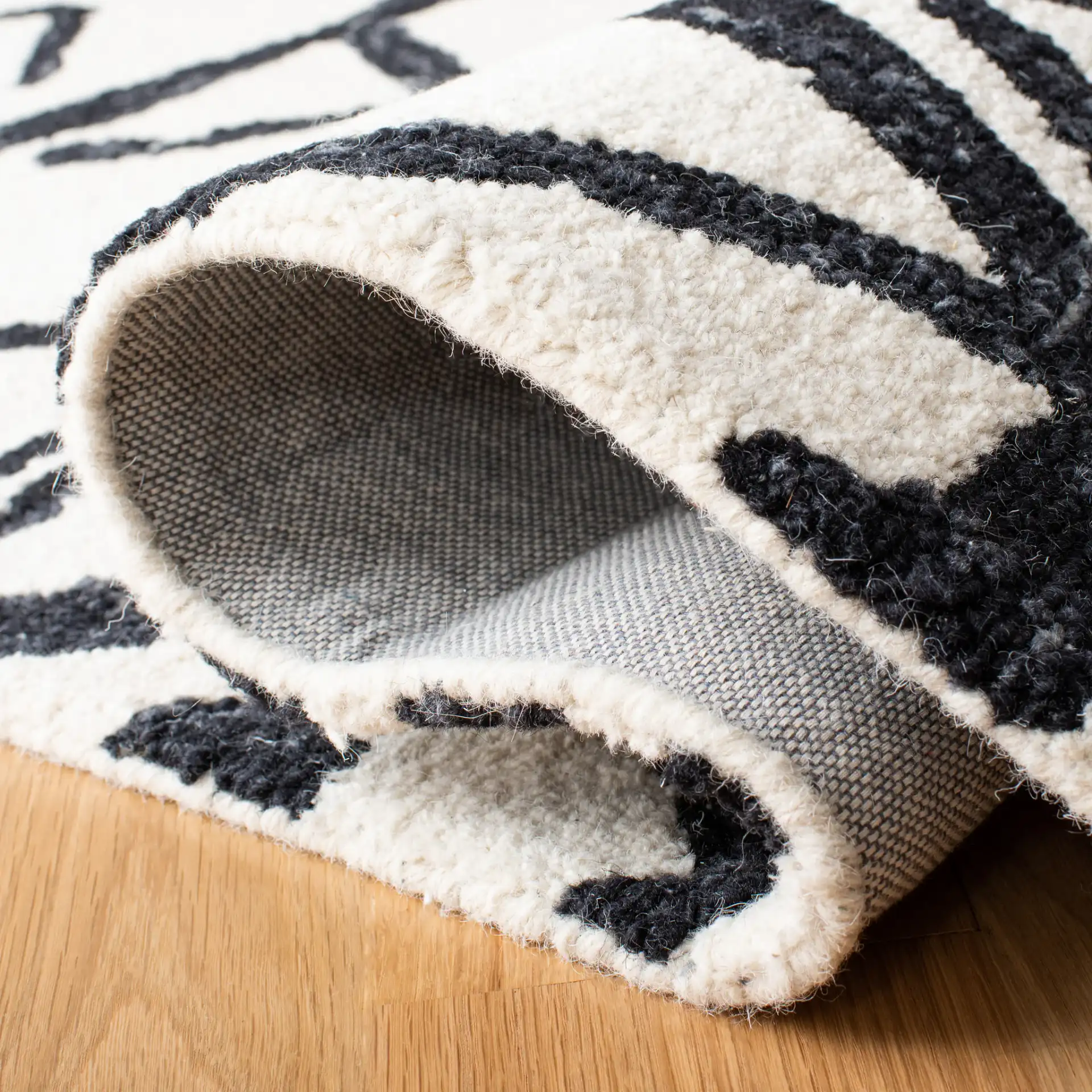 Metro Tribal Motif Stripe Hand-Tufted Wool Rug in Black / Ivory in a styled room
