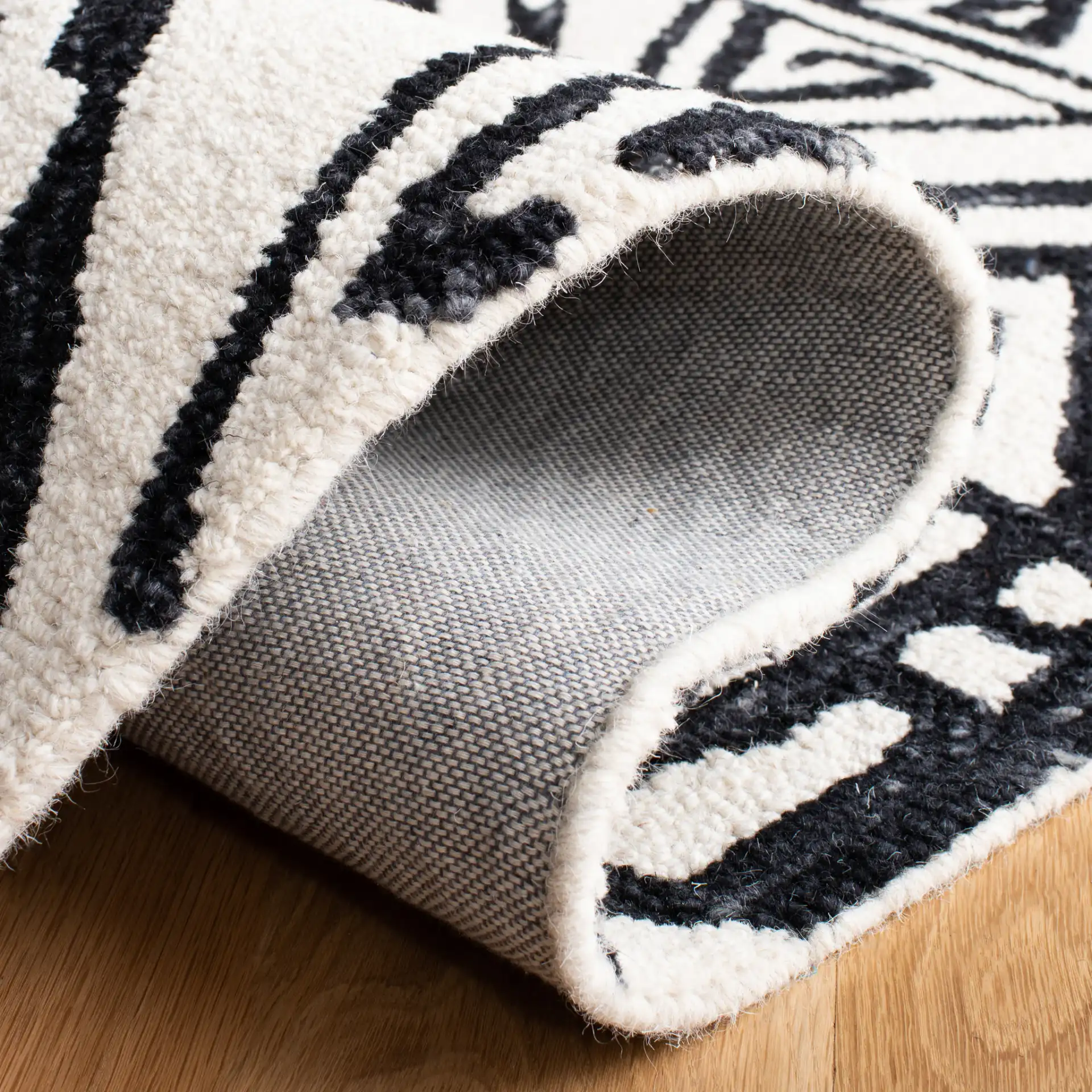 Metro Tribal Mask Hand-Tufted Wool Rug in Black / Ivory in a styled room