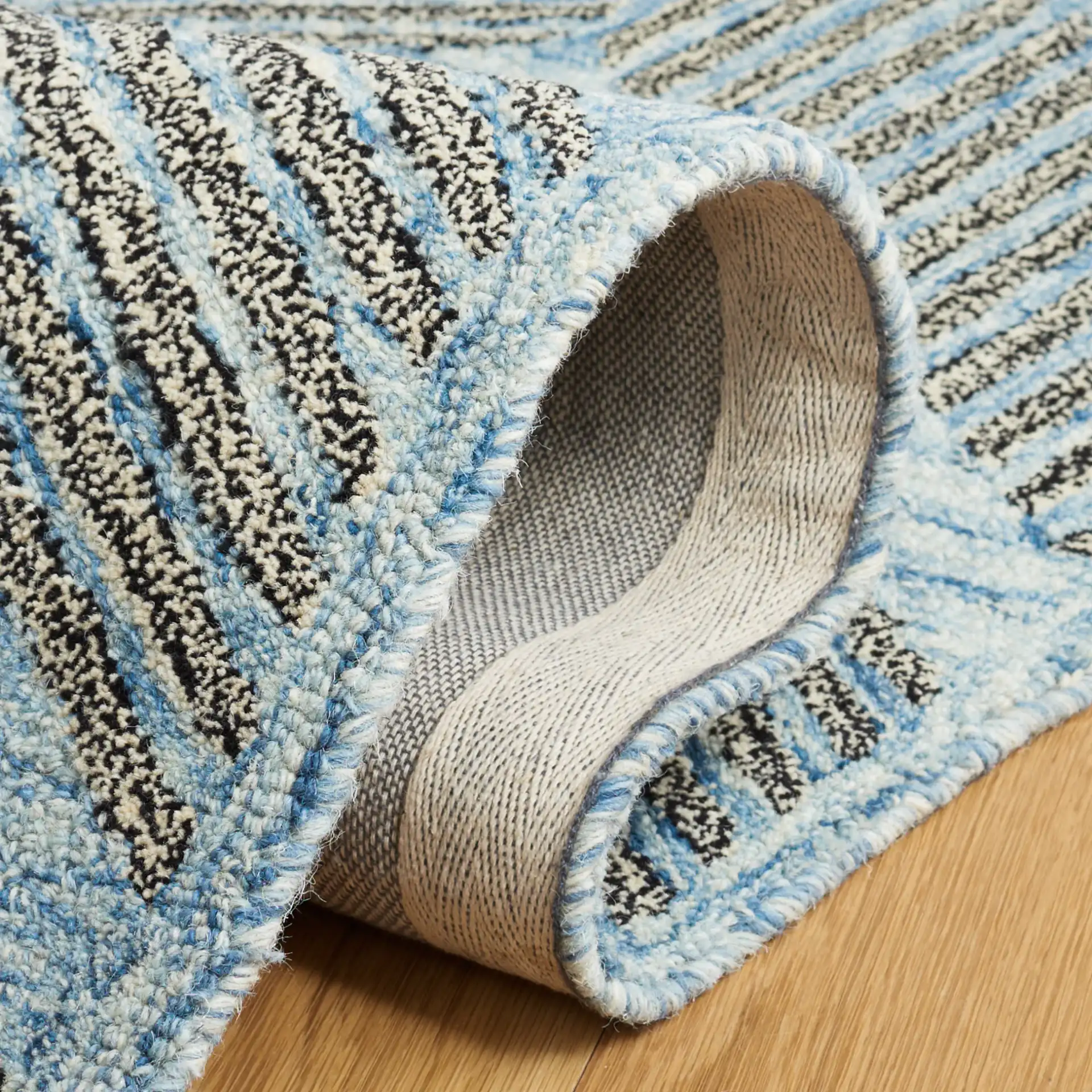 Metro Modern Chevron Hand-Tufted Wool Rug in Blue / Black in a styled room