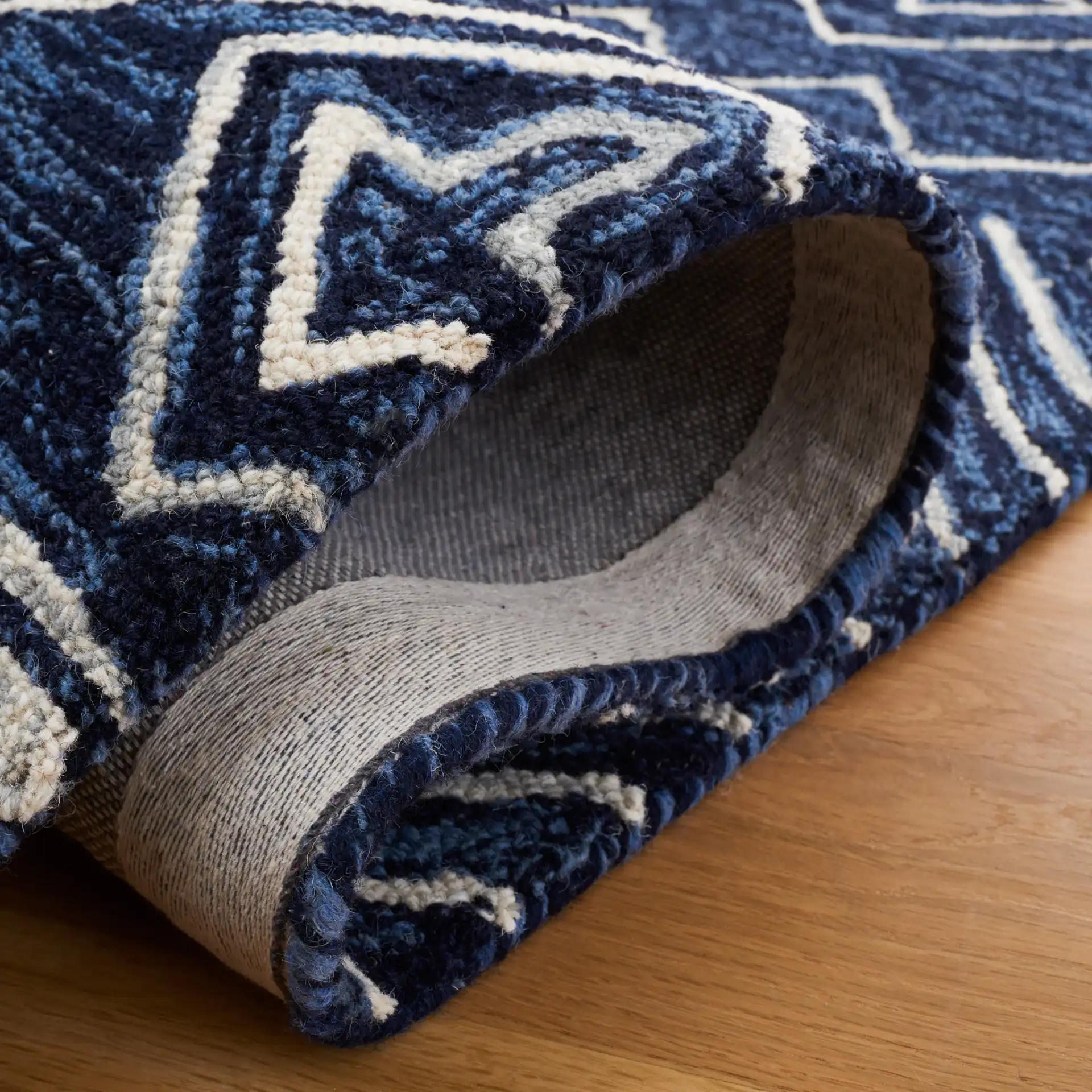 Metro Diamond Banded Hand-Tufted Wool Rug in Navy / Ivory in a styled room