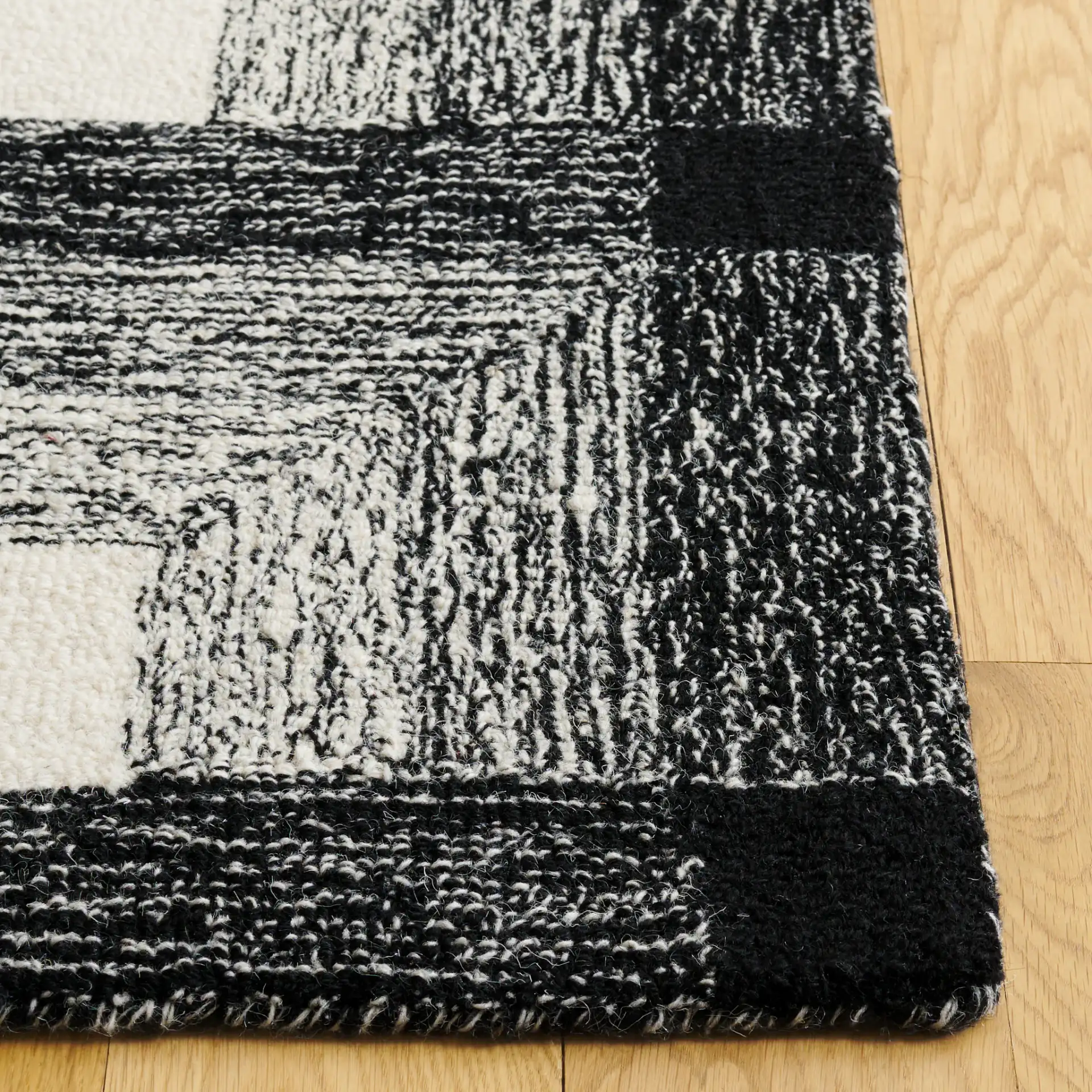 Metro Optical Grid Hand-Tufted Wool Rug in Charcoal / Ivory in a styled room