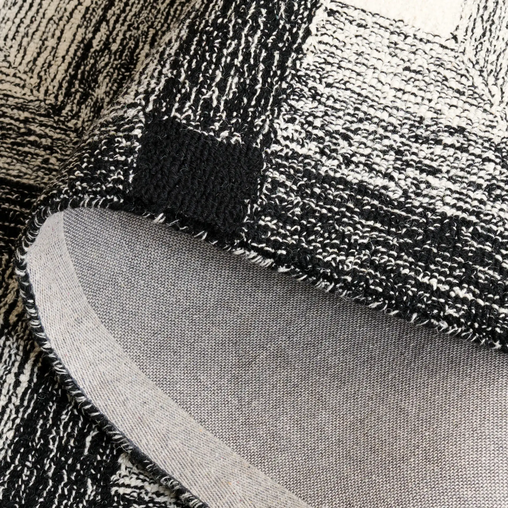 Metro Optical Grid Hand-Tufted Wool Rug in Charcoal / Ivory in a styled room