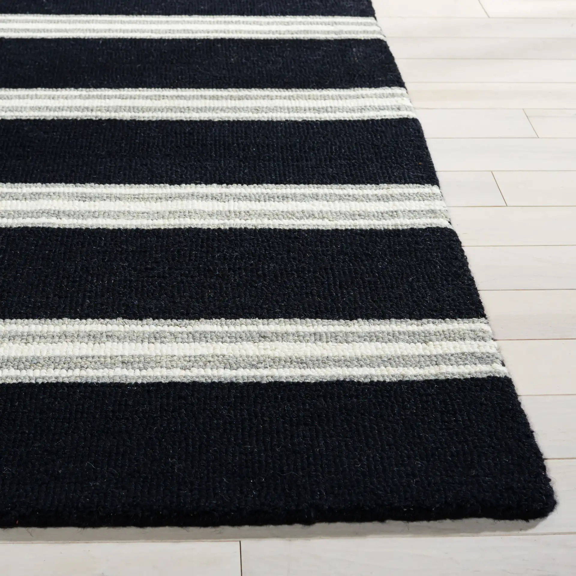 Metro Striped Hand-Tufted Wool Rug in Black / Ivory in a styled room