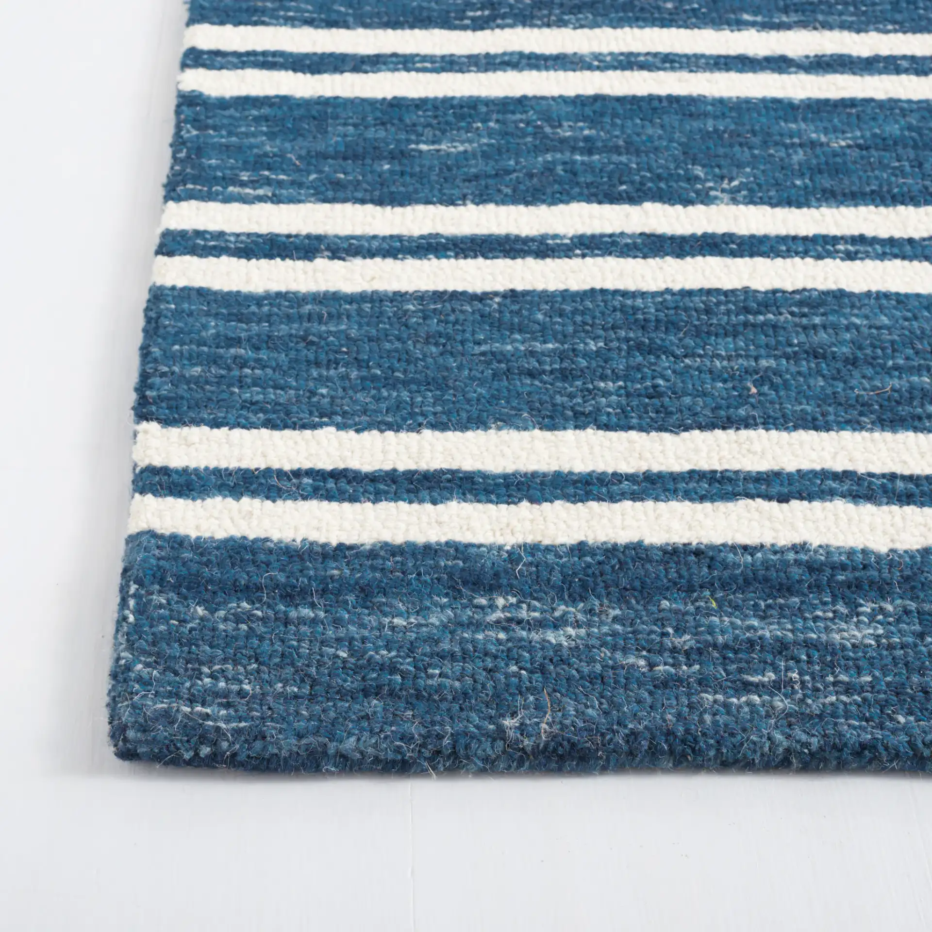 Metro Stripe Hand-Tufted Rug in Blue / Ivory in a styled room