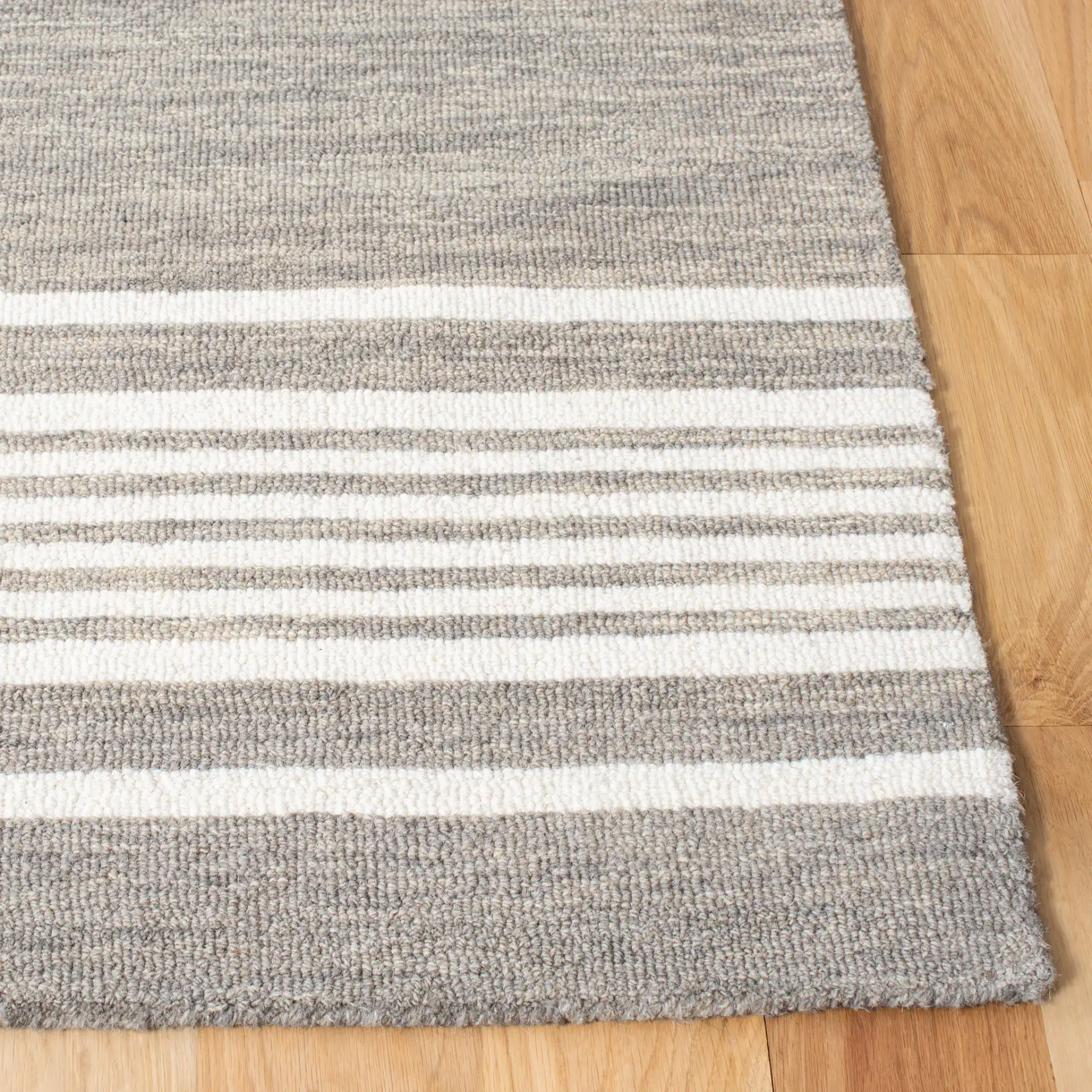 Metro Striped Border Hand-Tufted Wool Rug in Charcoal / Ivory in a styled room