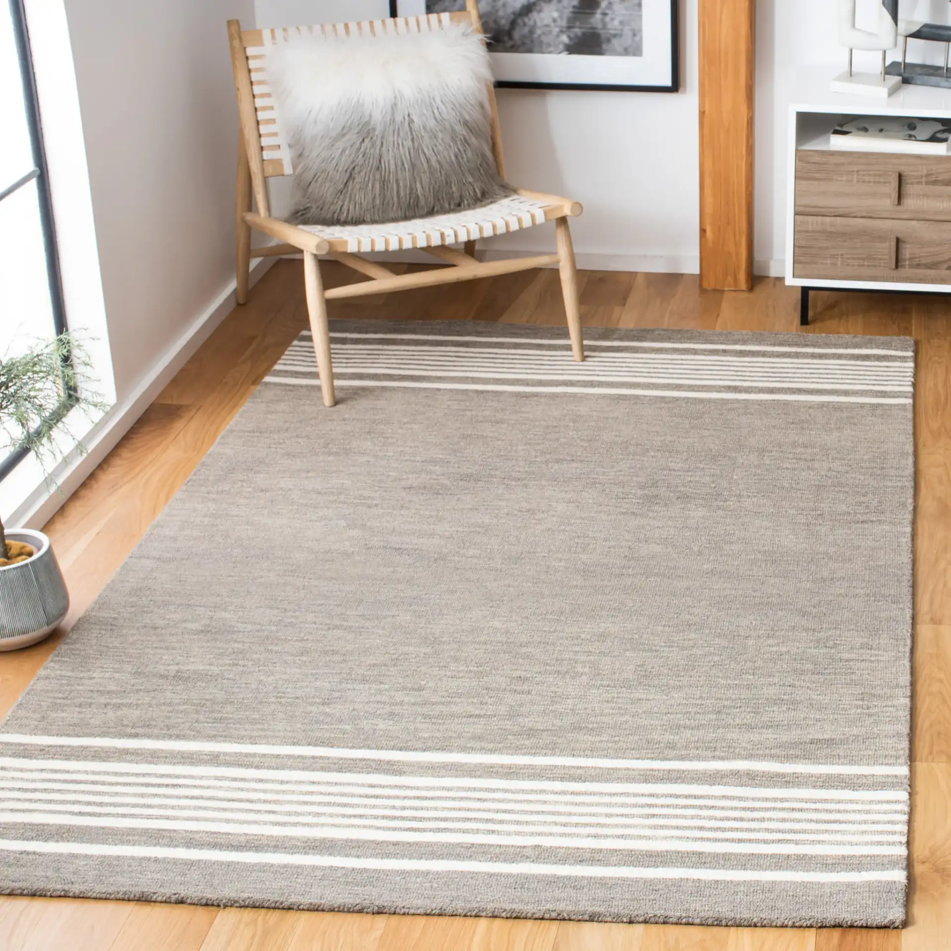 Metro Striped Border Hand-Tufted Wool Rug in Charcoal / Ivory in a styled room