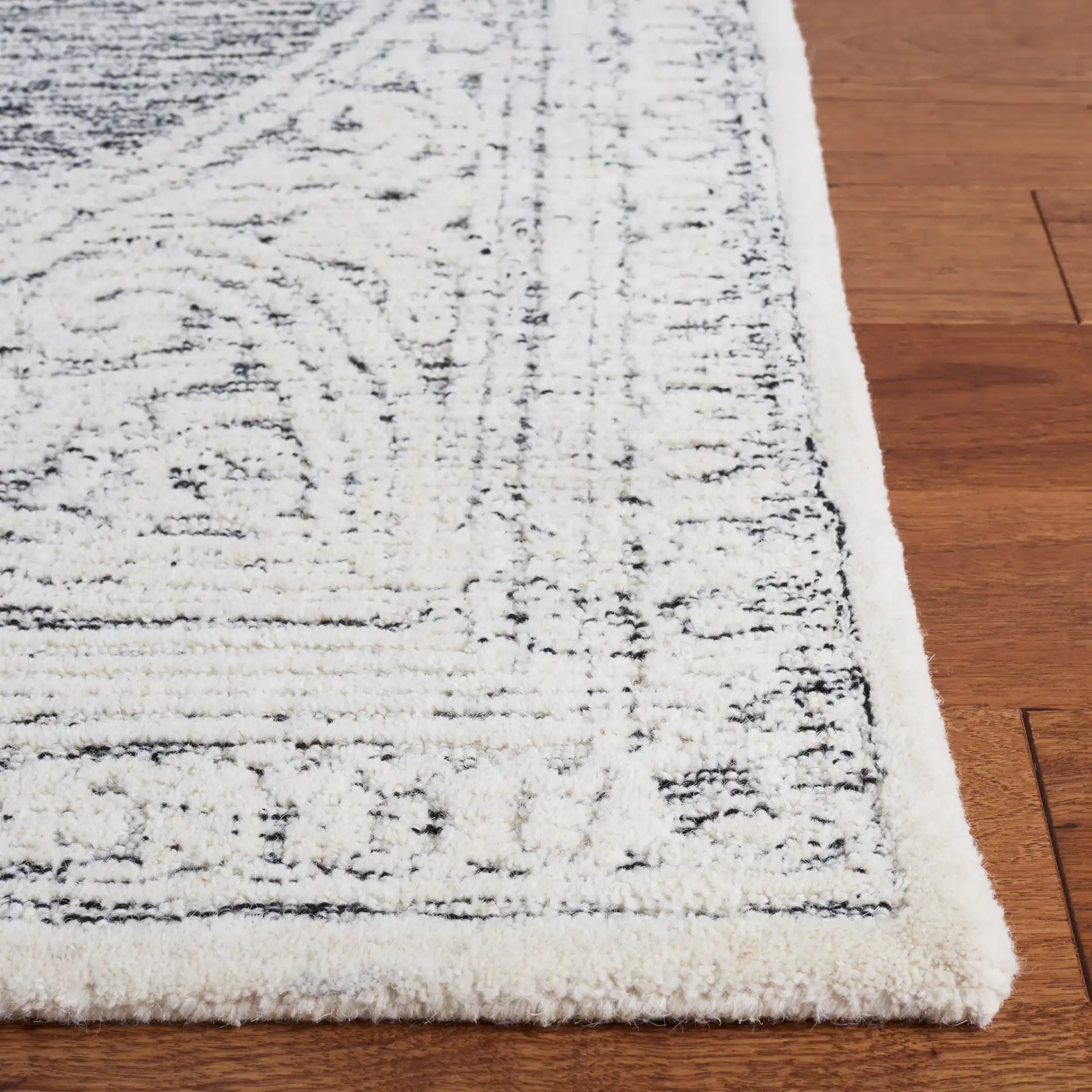 Metro Scroll Medallion Hand-Tufted Wool Rug in Ivory / Black in a styled room