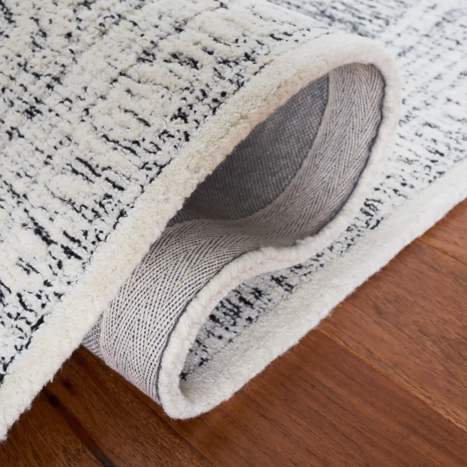 Metro Scroll Medallion Hand-Tufted Wool Rug in Ivory / Black in a styled room
