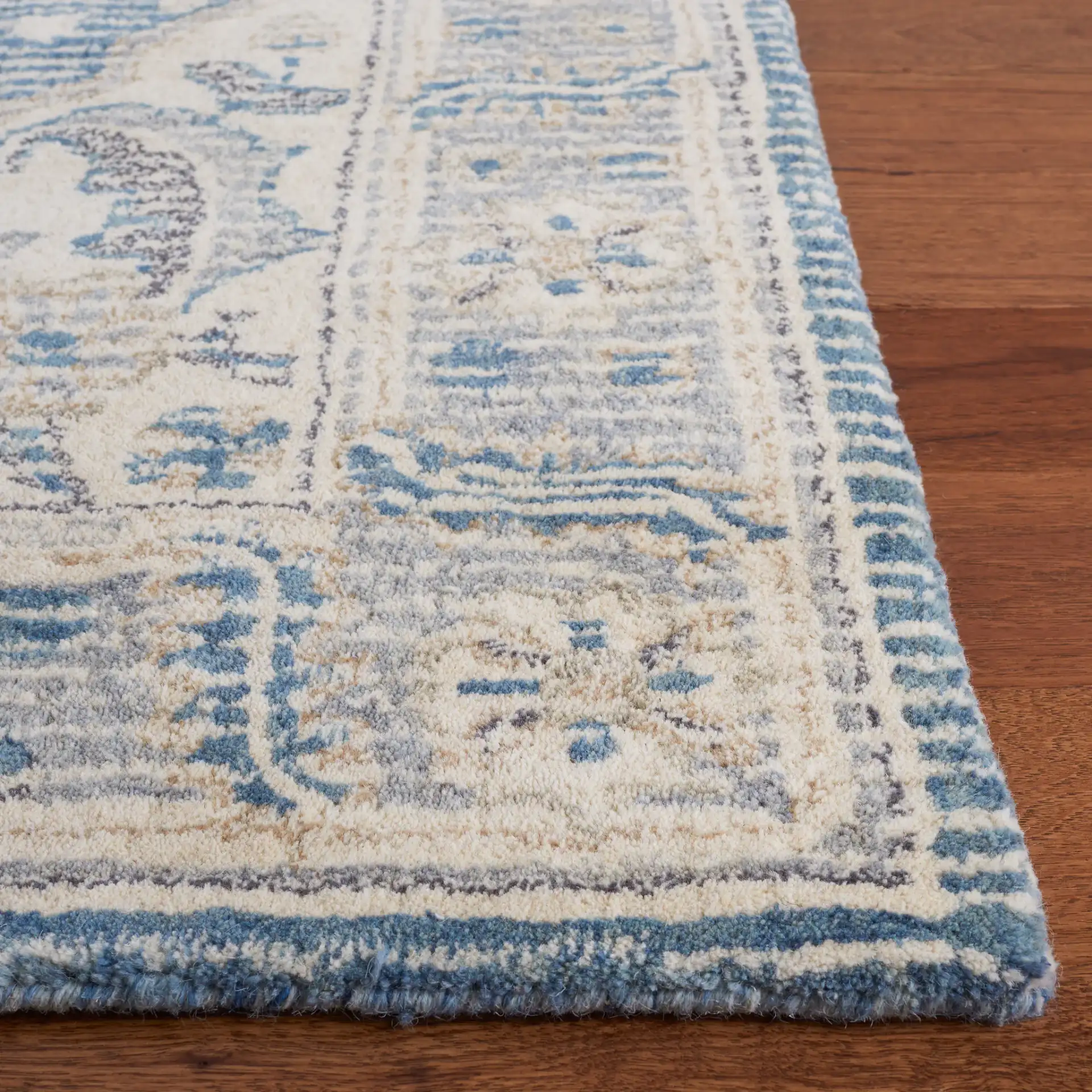 Metro Framed Medallion Hand-Tufted Wool Rug in Blue / Ivory in a styled room