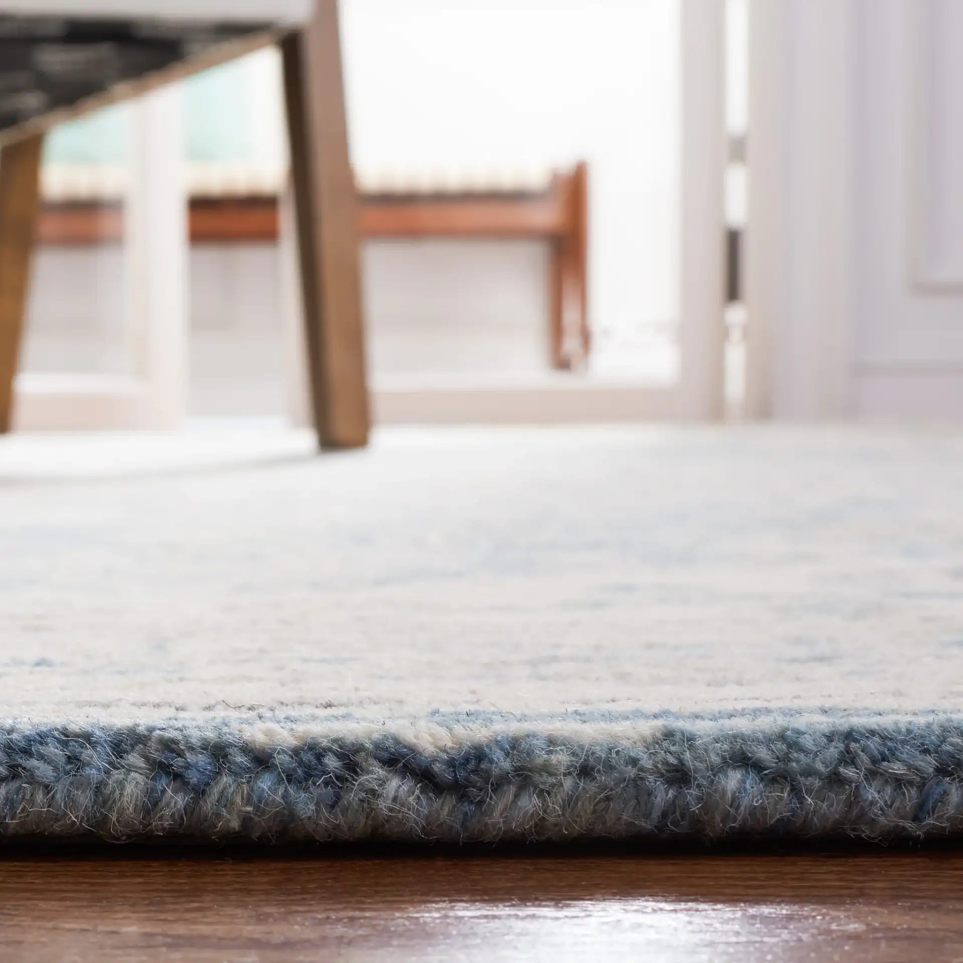 Metro Framed Medallion Hand-Tufted Wool Rug in Blue / Ivory in a styled room