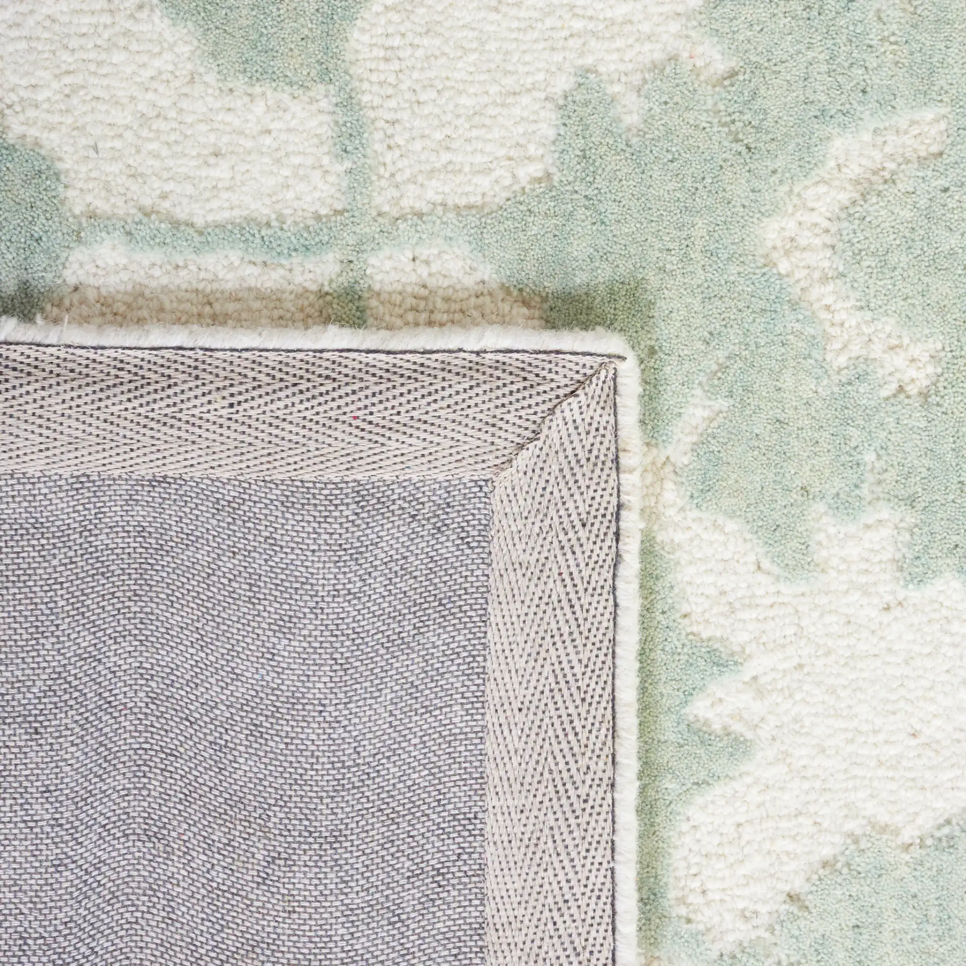 Metro Floral Vine Arabesque Hand-Tufted Wool Rug in Ivory / Light Green in a styled room