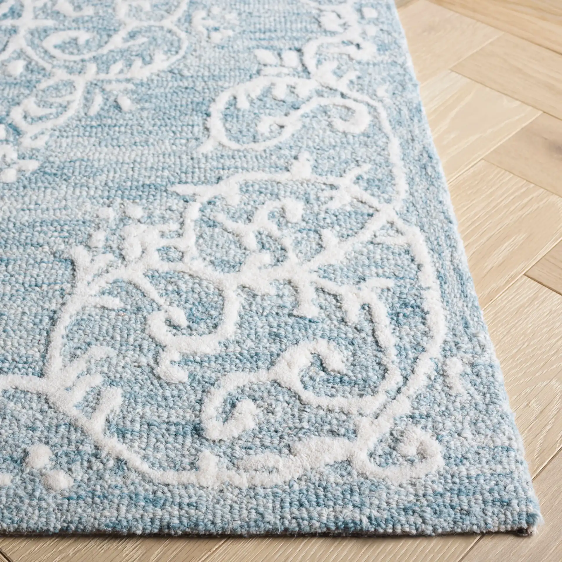 Metro Corner Medallion Hand-Tufted Wool Rug in Blue / Ivory in a styled room