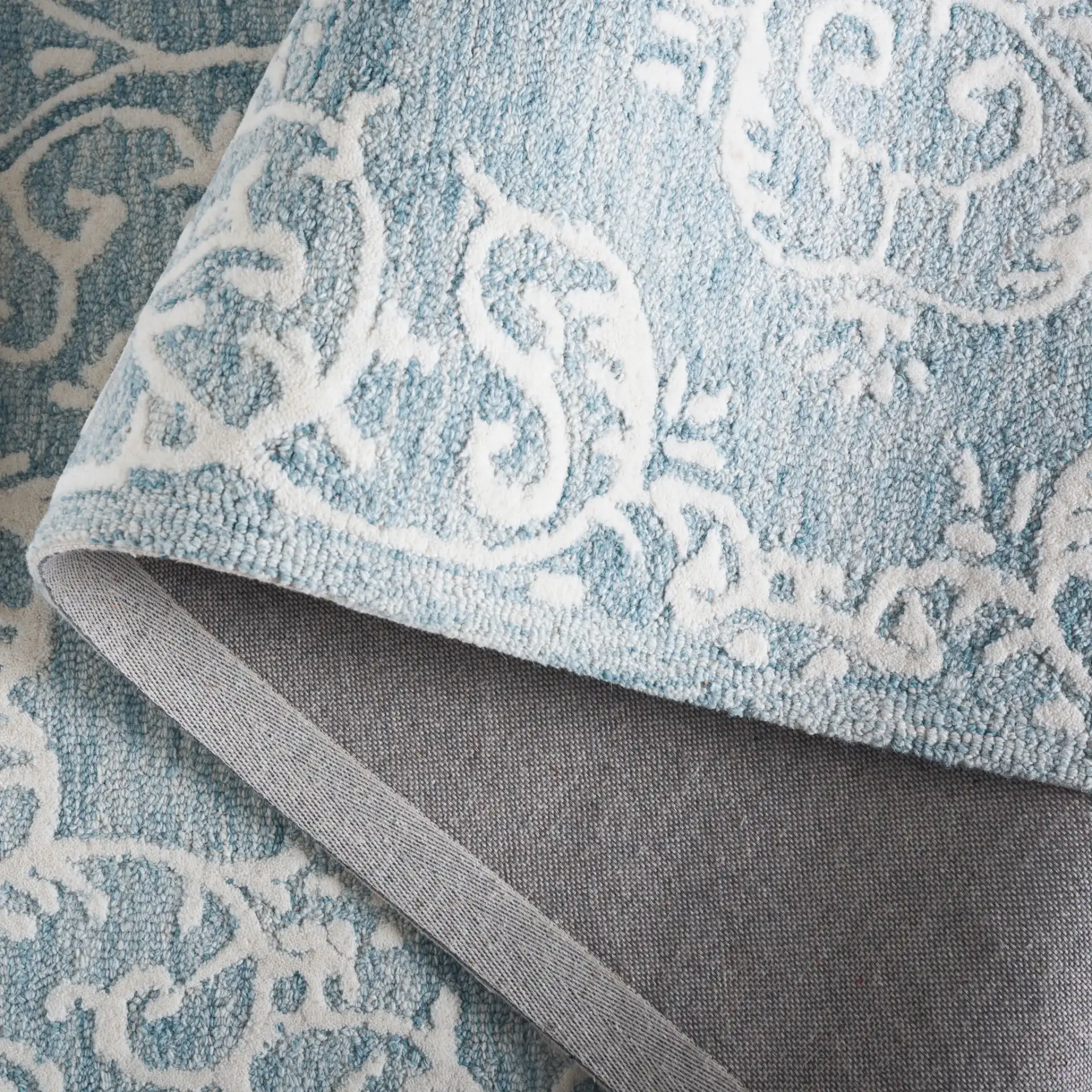 Metro Corner Medallion Hand-Tufted Wool Rug in Blue / Ivory in a styled room