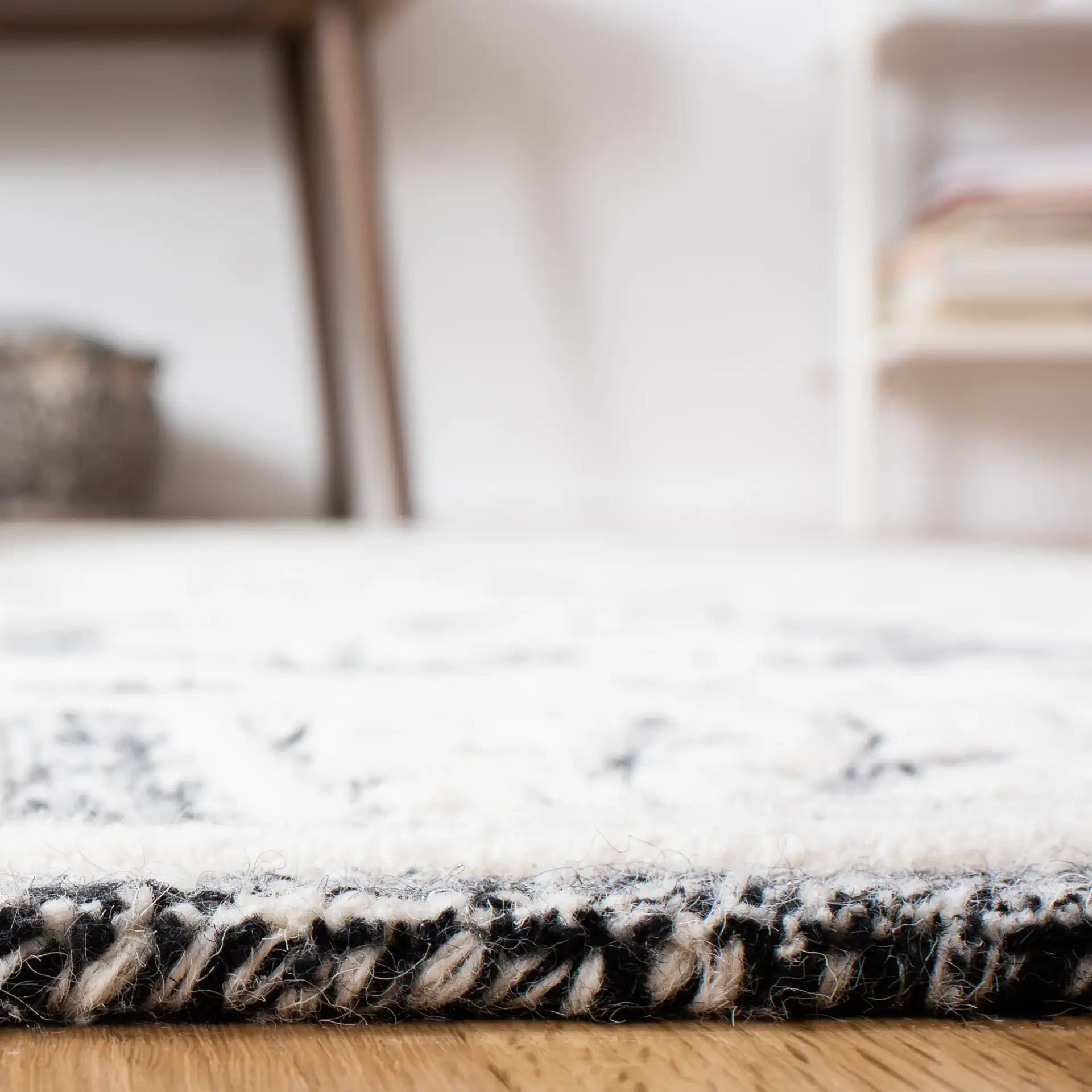Metro Tile Bordered Hand-Tufted Wool Rug in Black / Ivory in a styled room