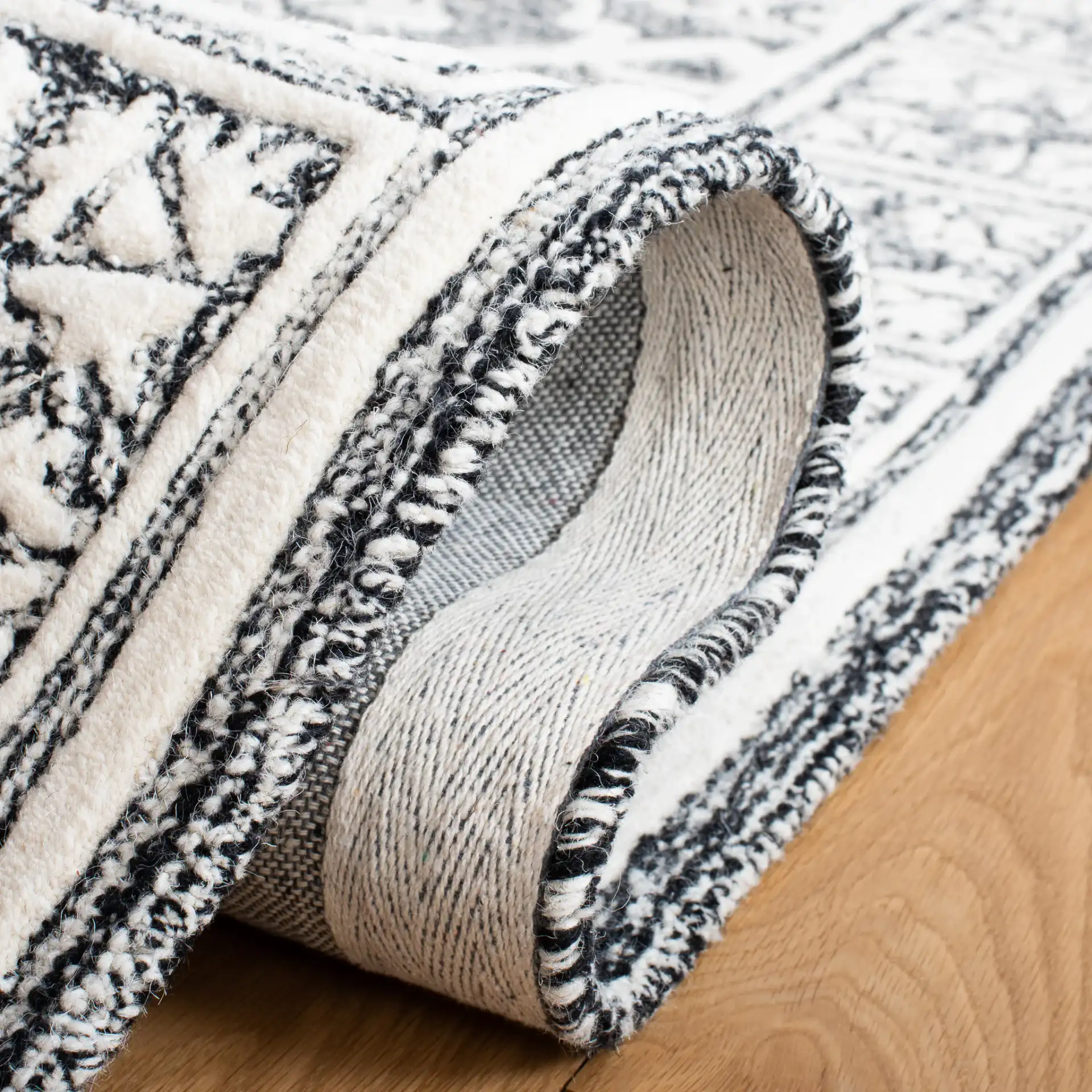 Metro Tile Bordered Hand-Tufted Wool Rug in Black / Ivory in a styled room