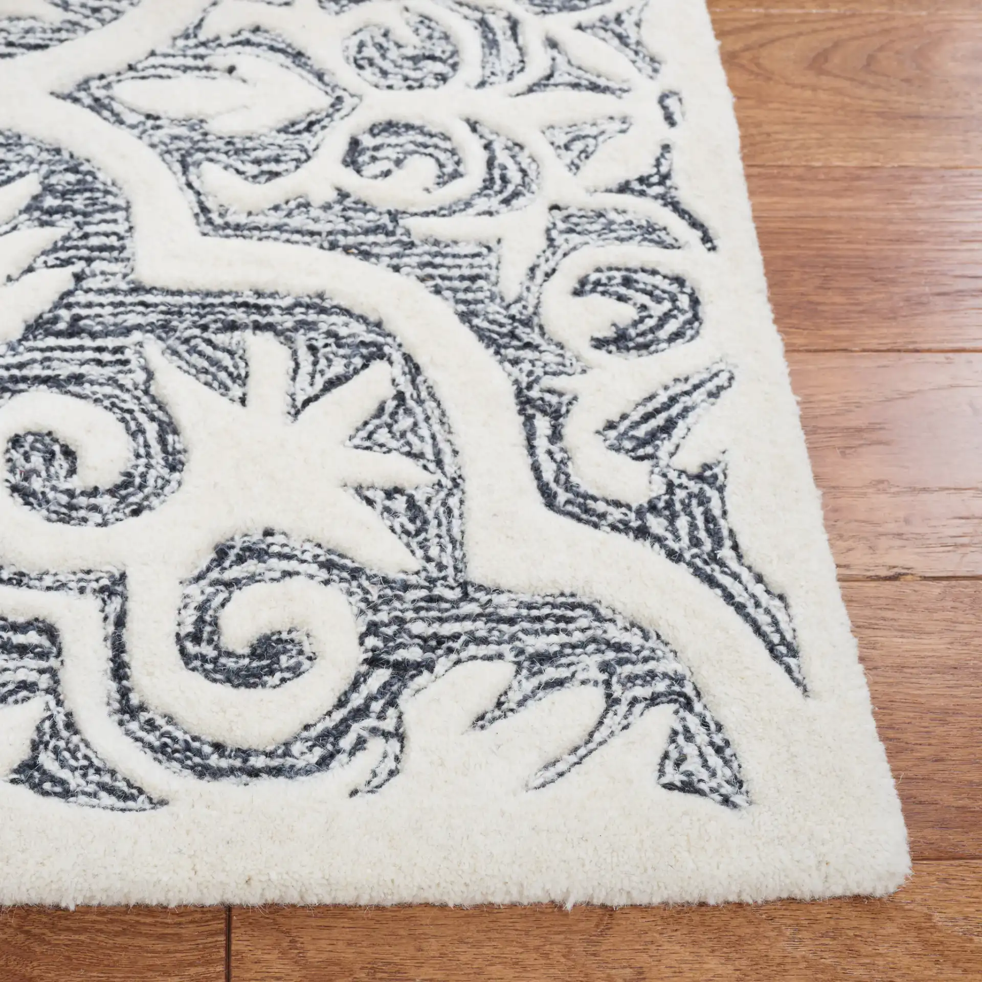 Metro Quatrefoil Tile Hand-Tufted Wool Rug in Black / Ivory in a styled room