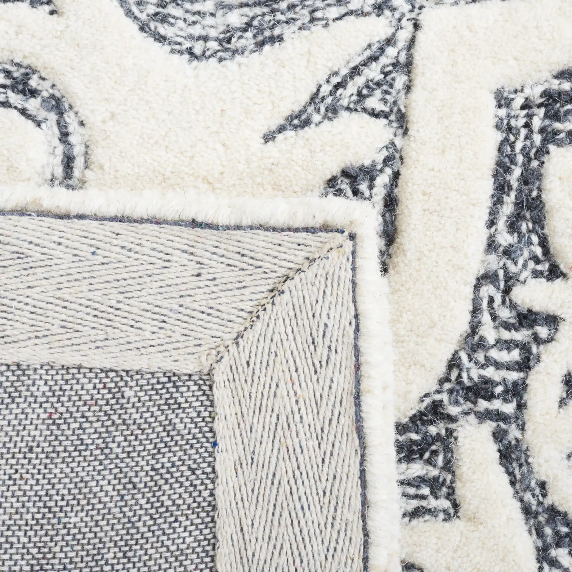 Metro Quatrefoil Tile Hand-Tufted Wool Rug in Black / Ivory in a styled room