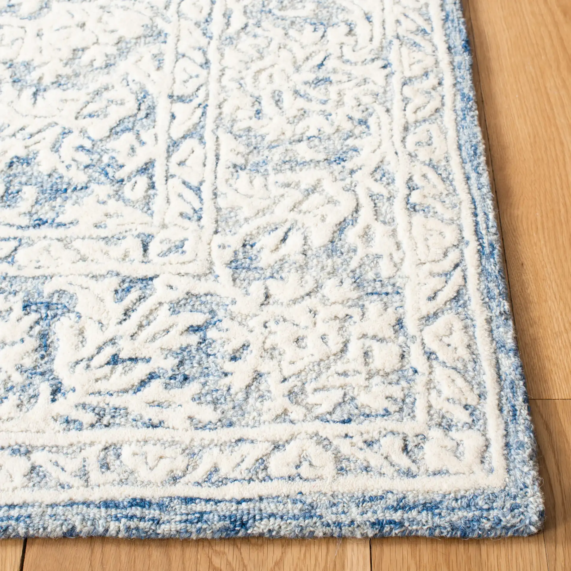 Metro Floral Border Hand-Tufted Wool Rug in Blue / Ivory in a styled room