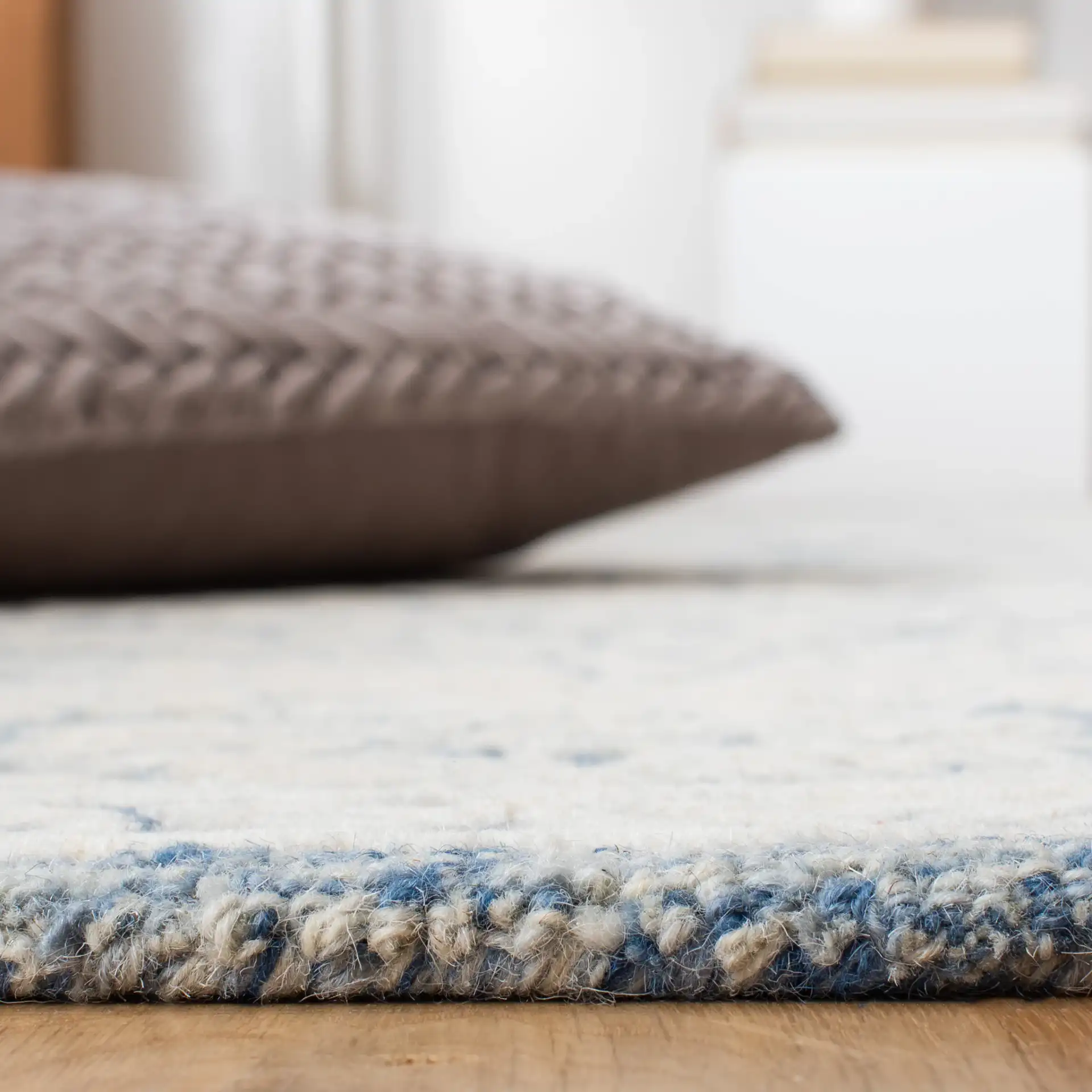 Metro Floral Border Hand-Tufted Wool Rug in Blue / Ivory in a styled room