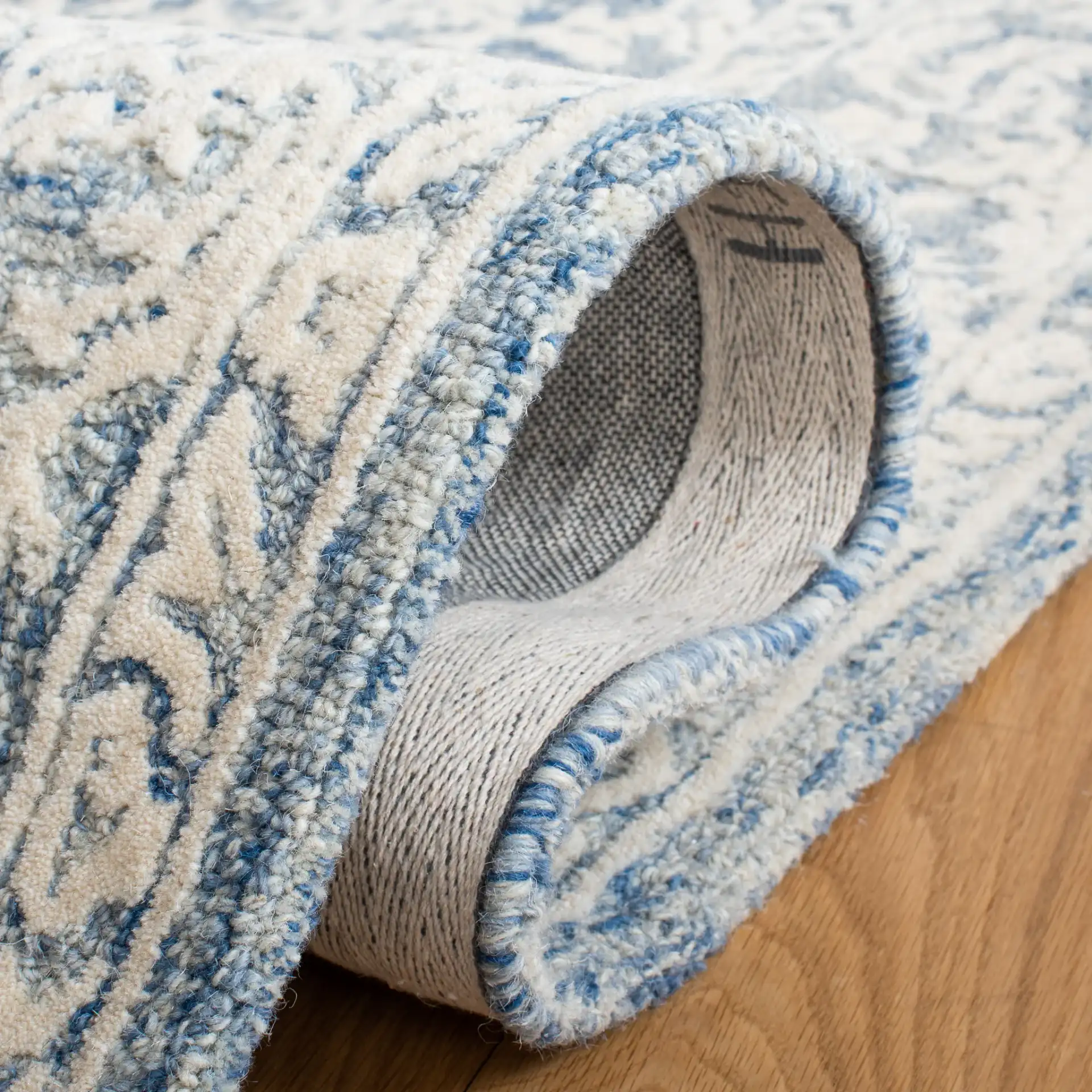Metro Floral Border Hand-Tufted Wool Rug in Blue / Ivory in a styled room