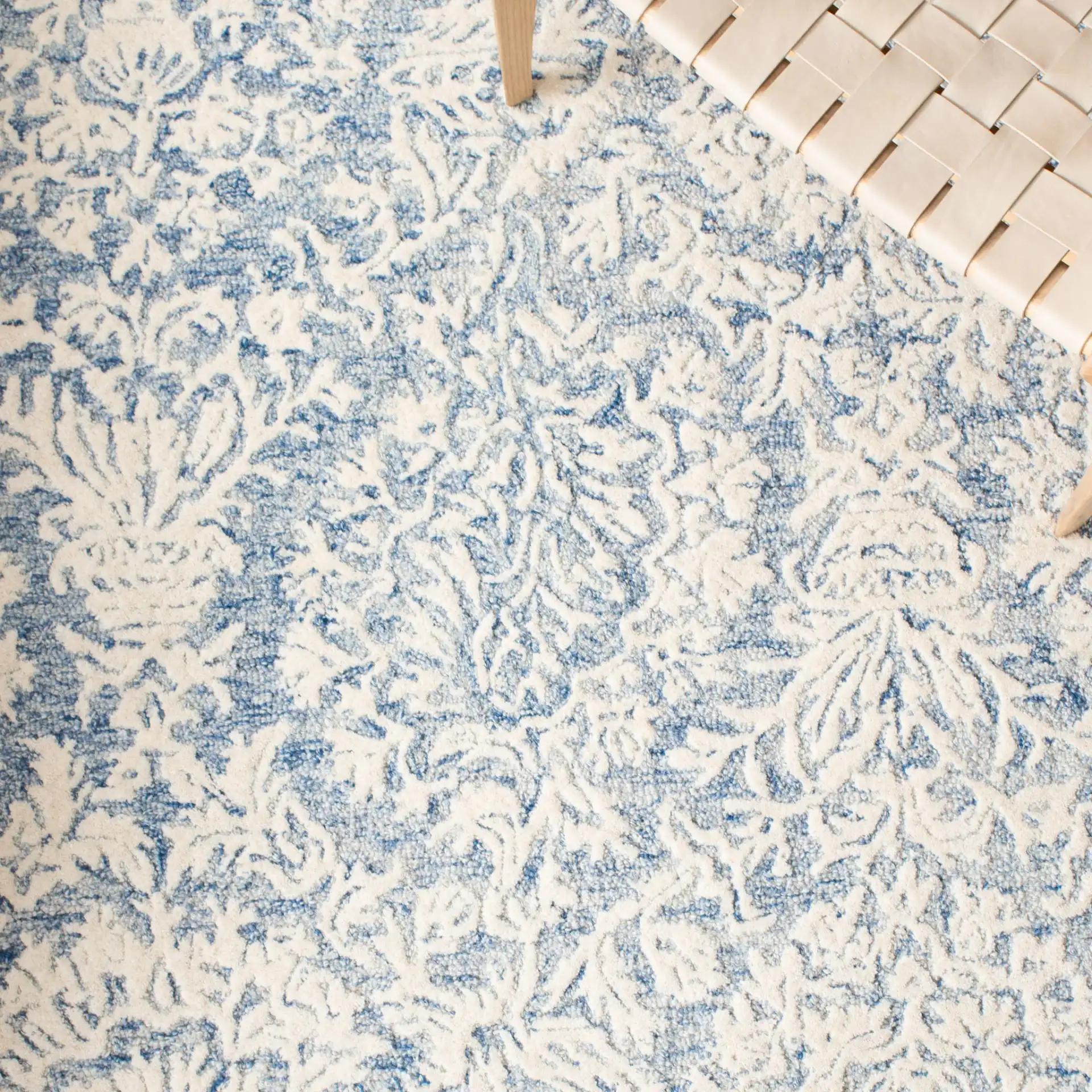 Metro Floral Border Hand-Tufted Wool Rug in Blue / Ivory in a styled room