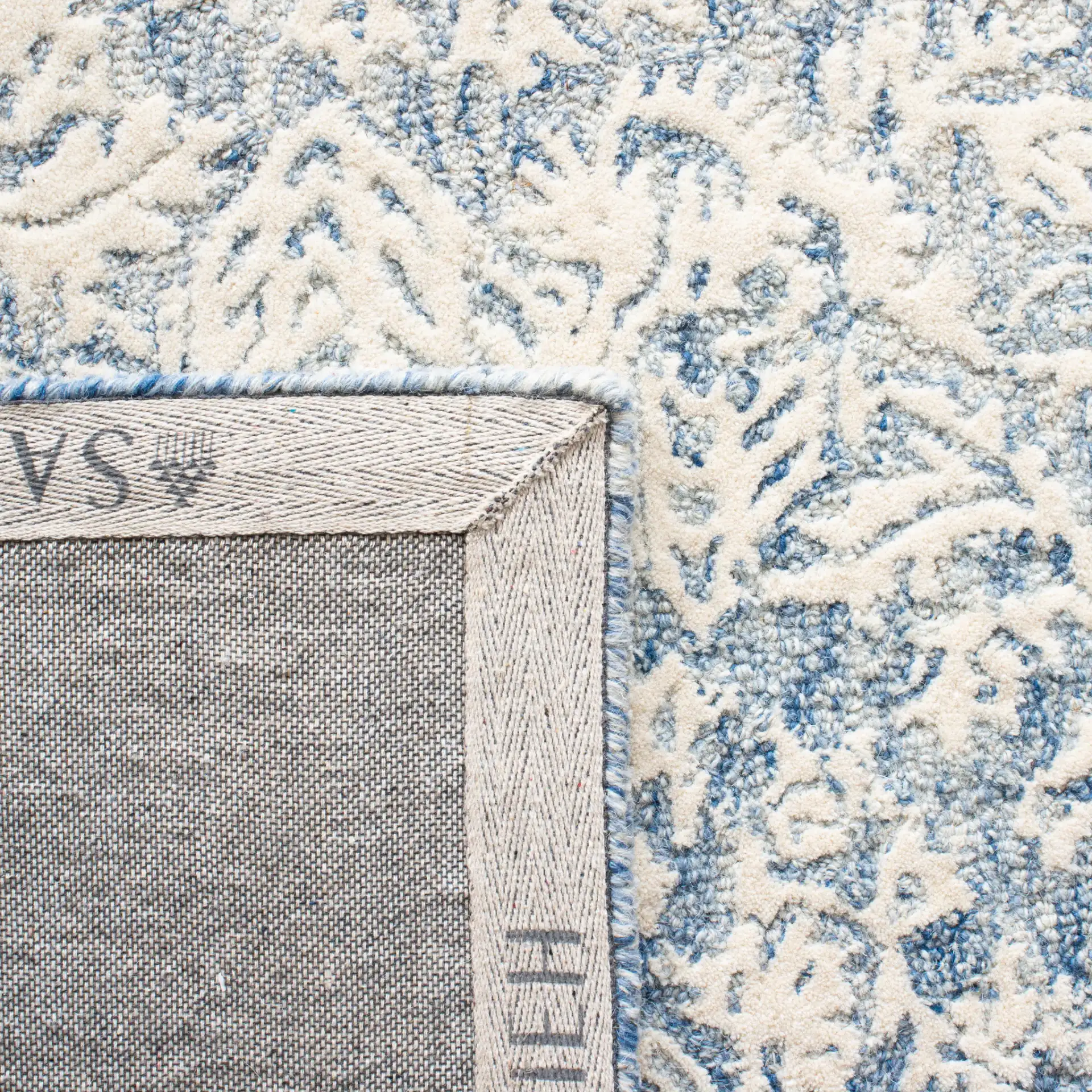 Metro Floral Border Hand-Tufted Wool Rug in Blue / Ivory in a styled room
