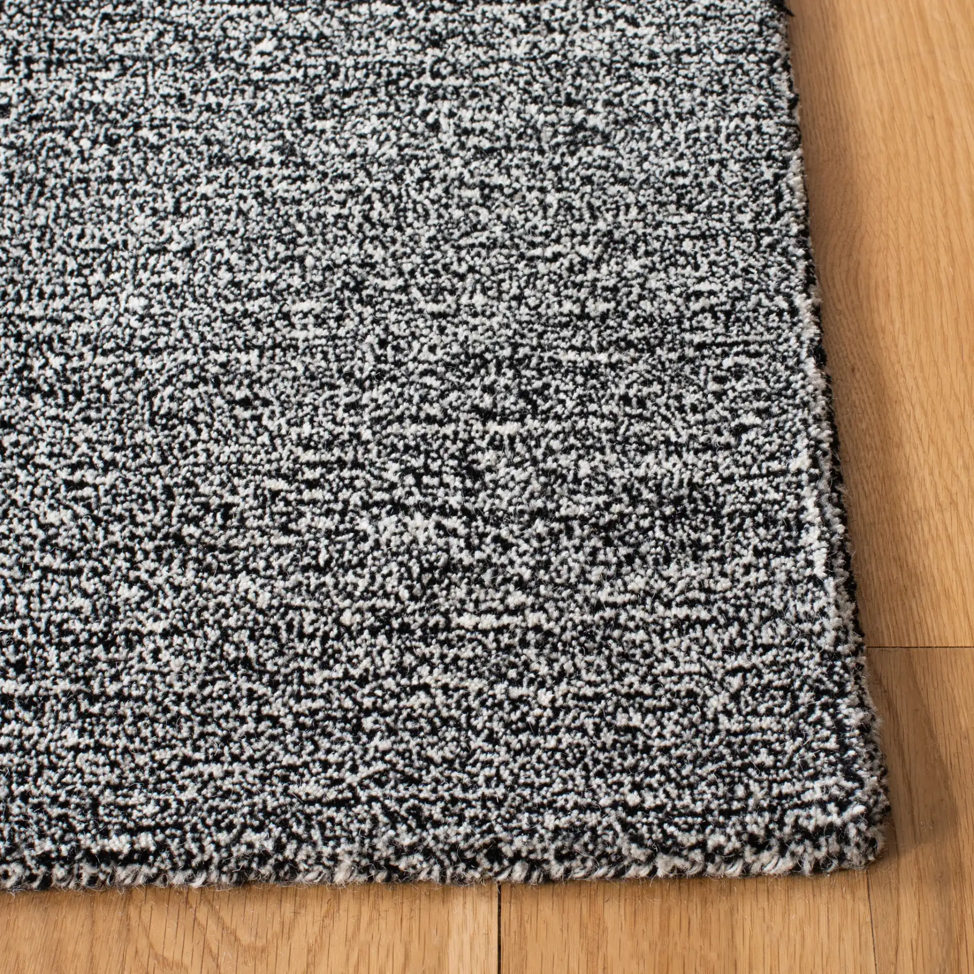Metro Modern Heathered Solid Hand-Tufted Wool Rug in Black / Ivory in a styled room