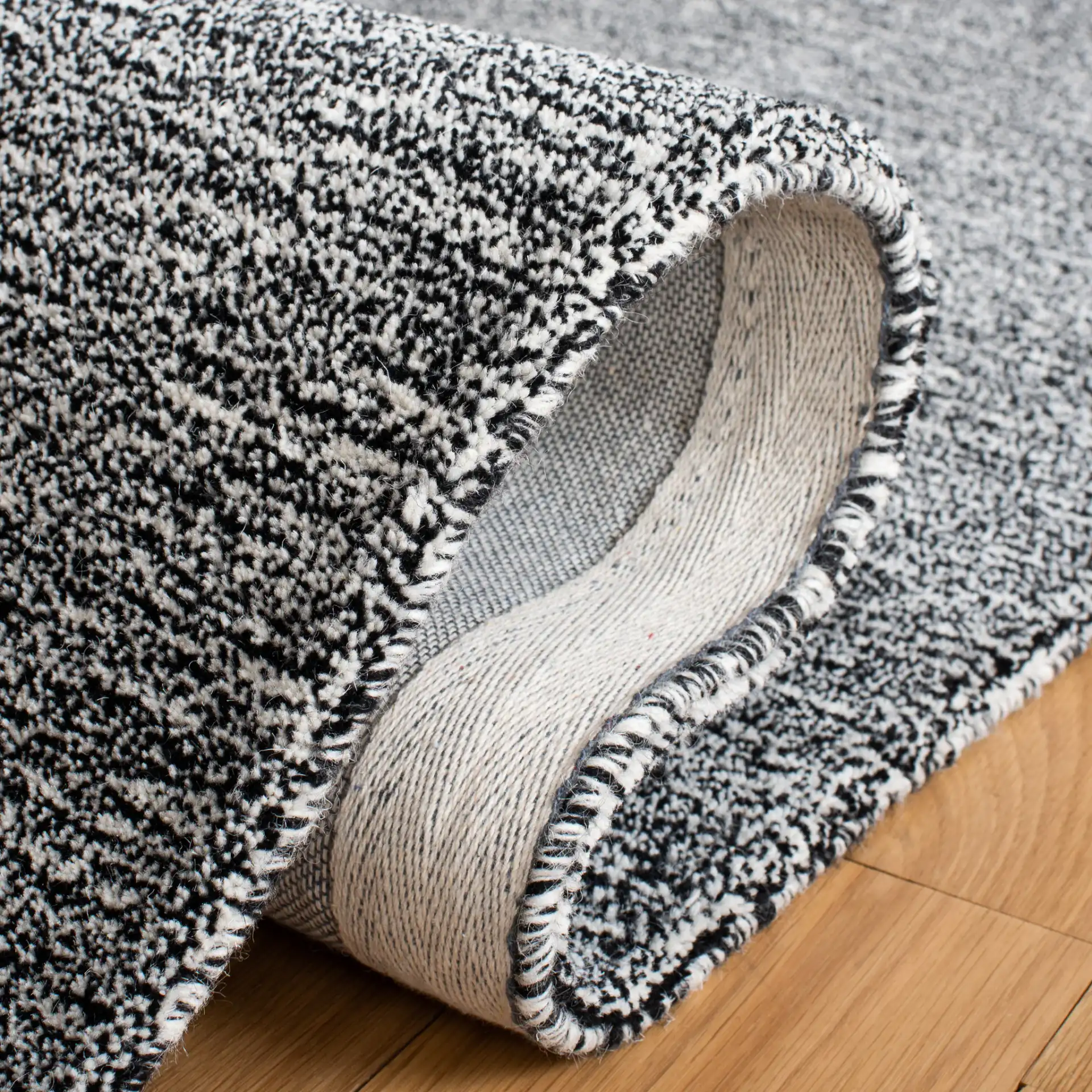 Metro Modern Heathered Solid Hand-Tufted Wool Rug in Black / Ivory in a styled room