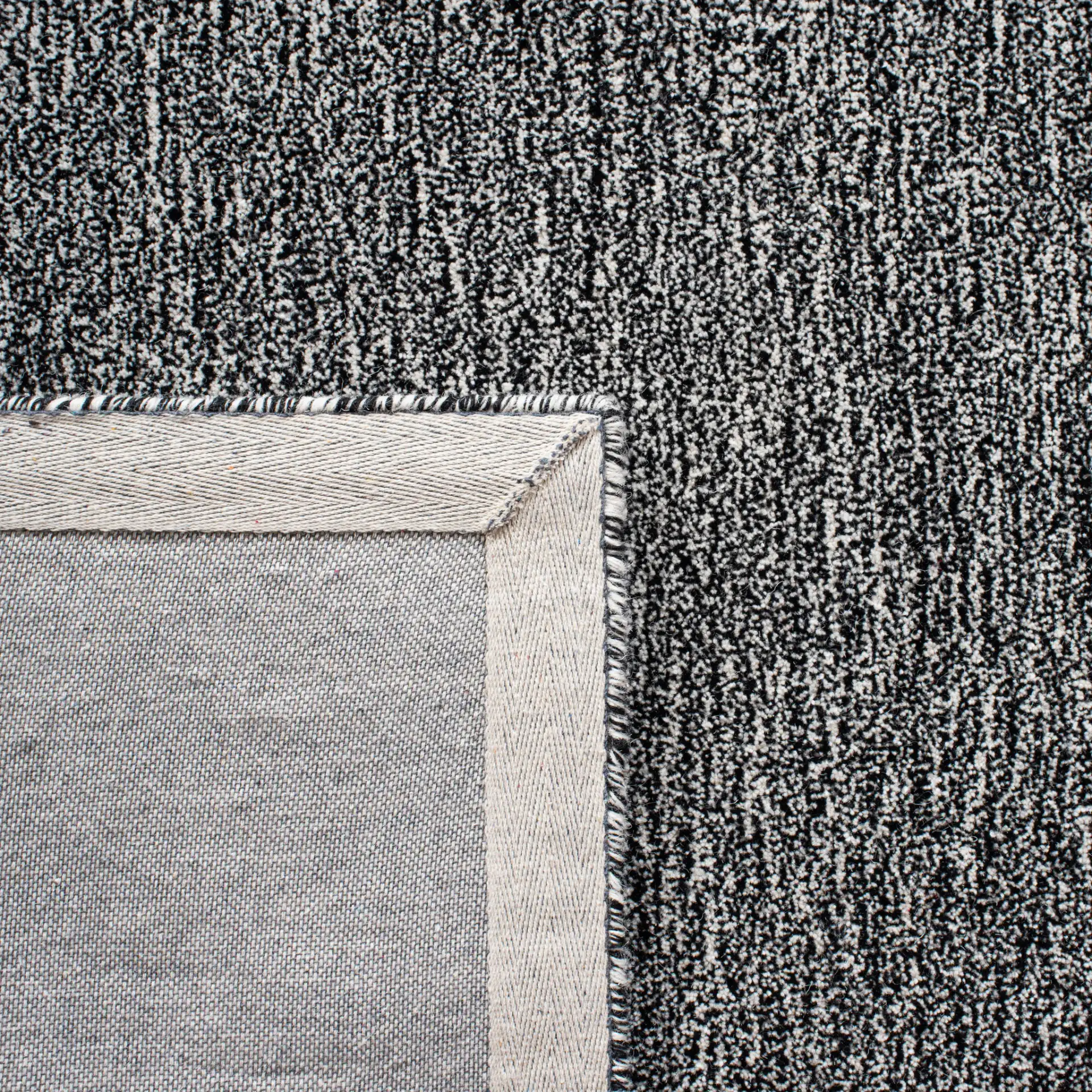 Metro Modern Heathered Solid Hand-Tufted Wool Rug in Black / Ivory in a styled room