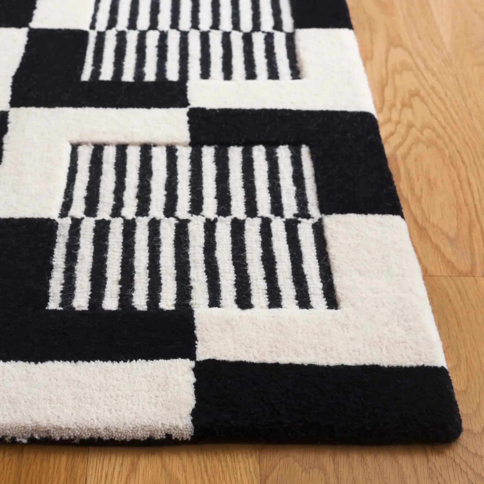 Metro Striped Checkerboard Hand-Tufted Wool Rug in Black / Ivory in a styled room