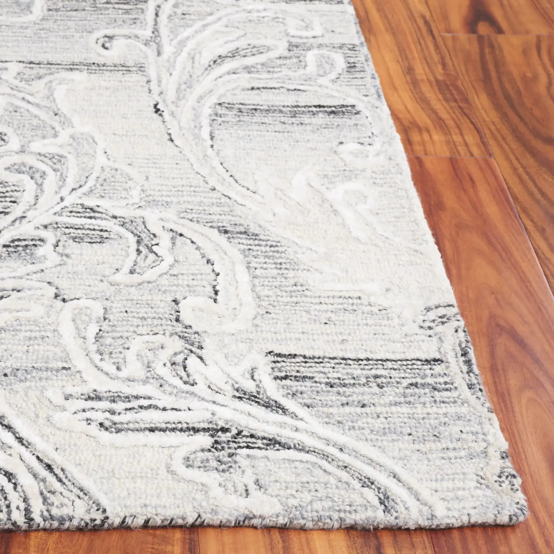 Metro Floral Scroll Hand-Tufted Wool Rug in Gray / Ivory in a styled room