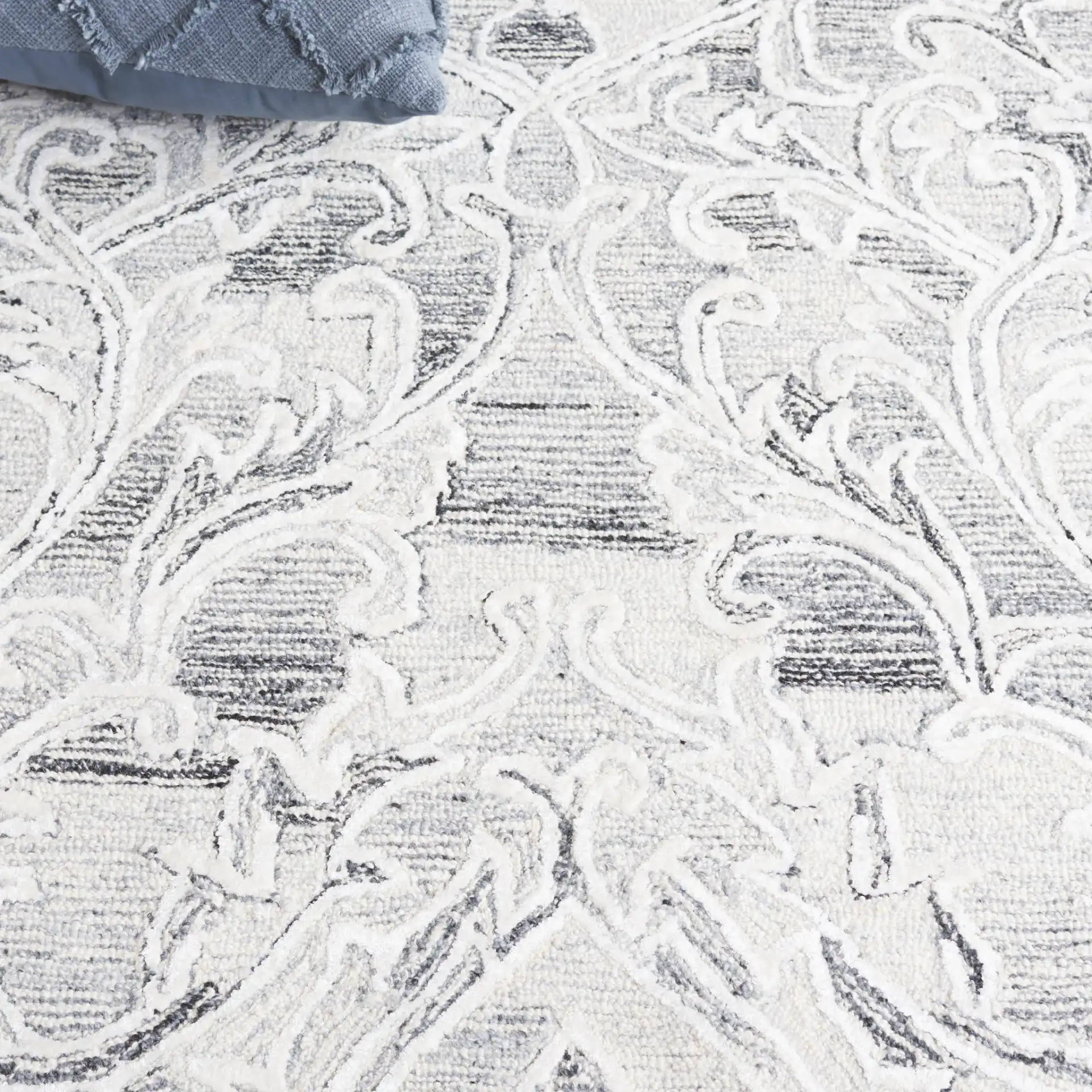 Metro Floral Scroll Hand-Tufted Wool Rug in Gray / Ivory in a styled room