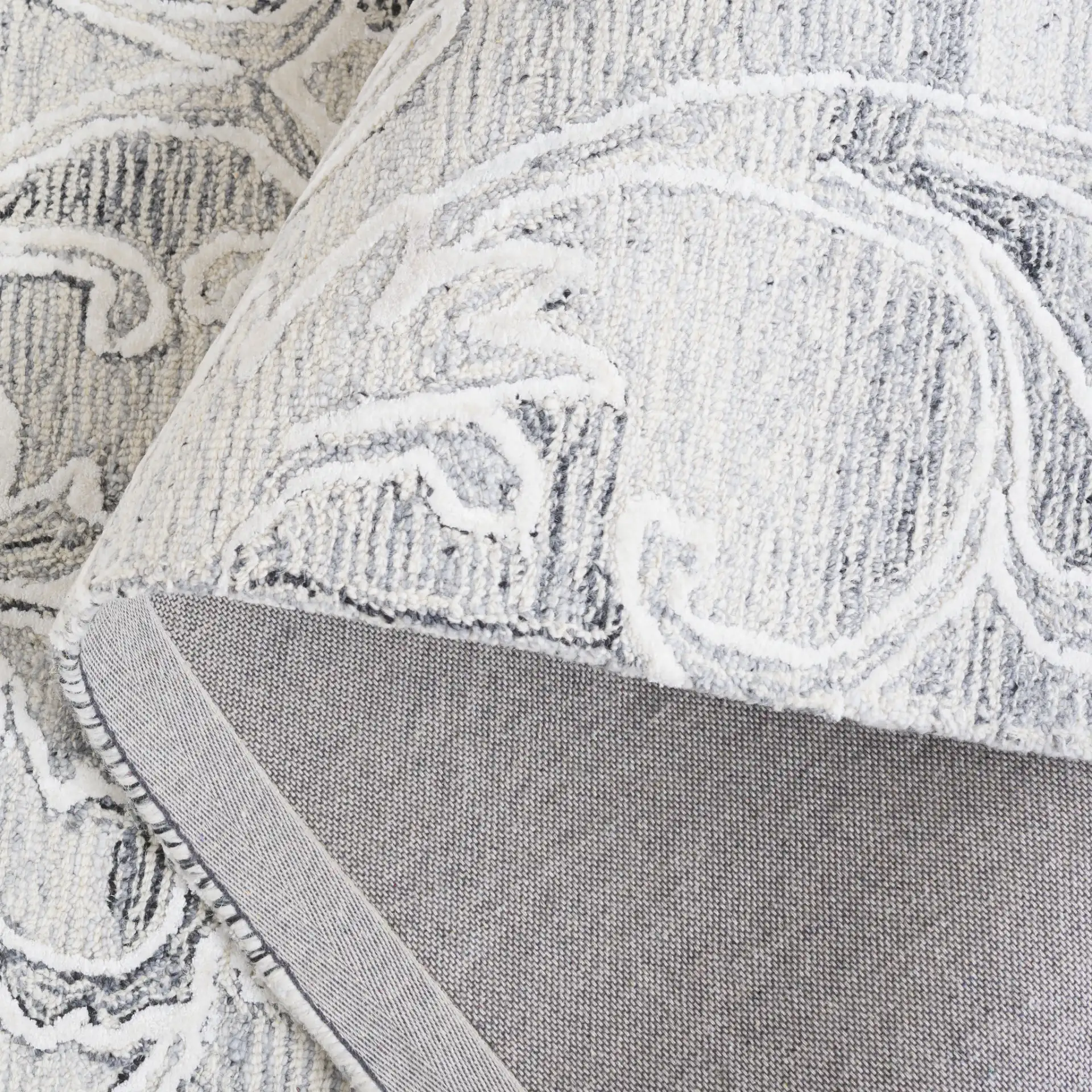 Metro Floral Scroll Hand-Tufted Wool Rug in Gray / Ivory in a styled room