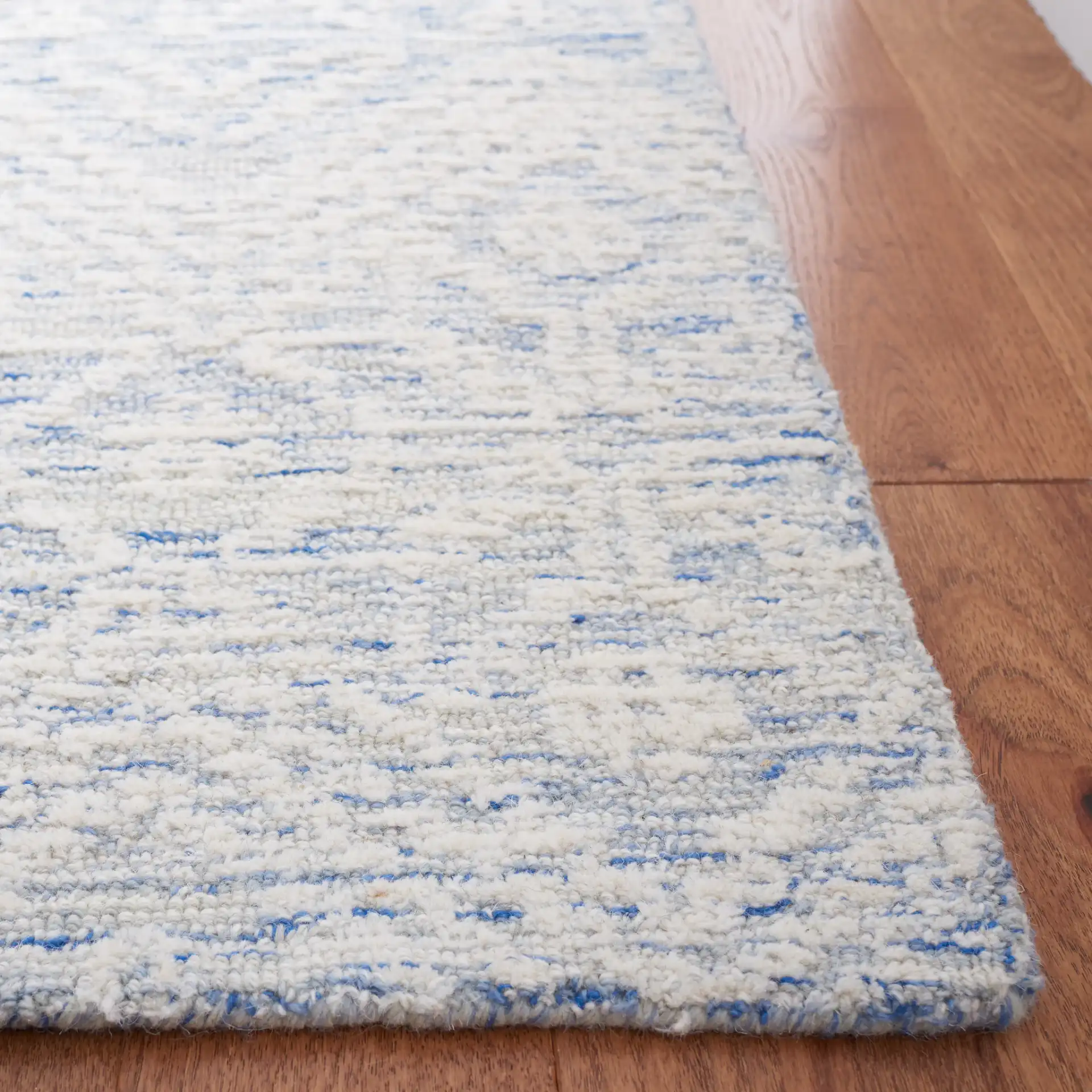 Metro Mottled Allover Hand-Tufted Wool Rug in Blue / Ivory in a styled room