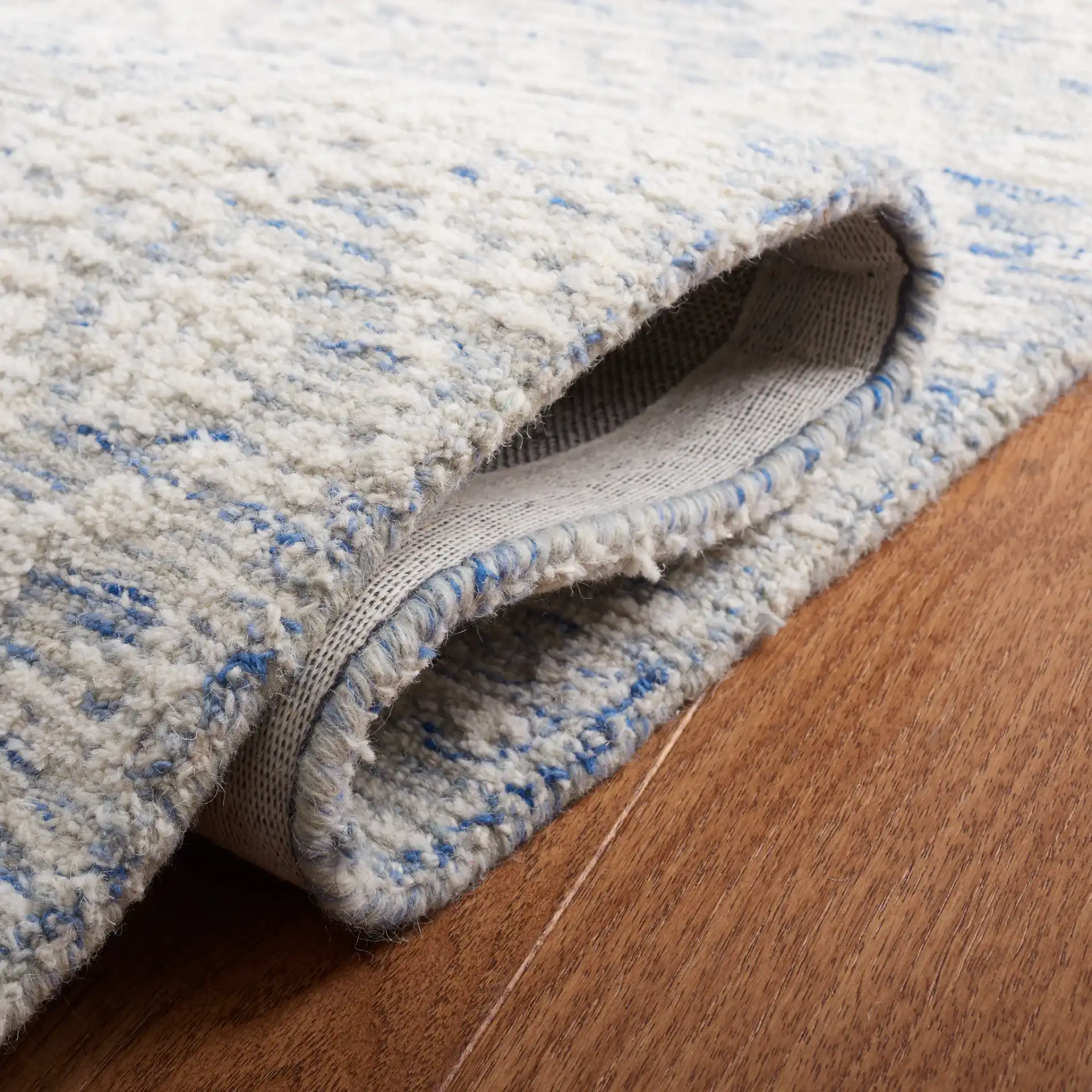 Metro Mottled Allover Hand-Tufted Wool Rug in Blue / Ivory in a styled room