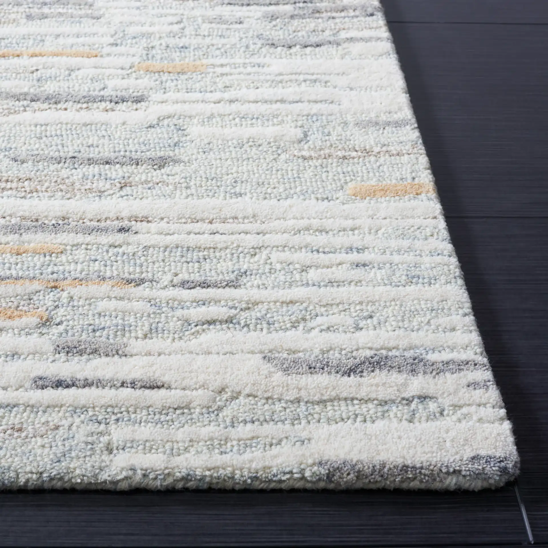 Metro Abstract Striated Hand-Tufted Wool Rug in Natural / Gold in a styled room