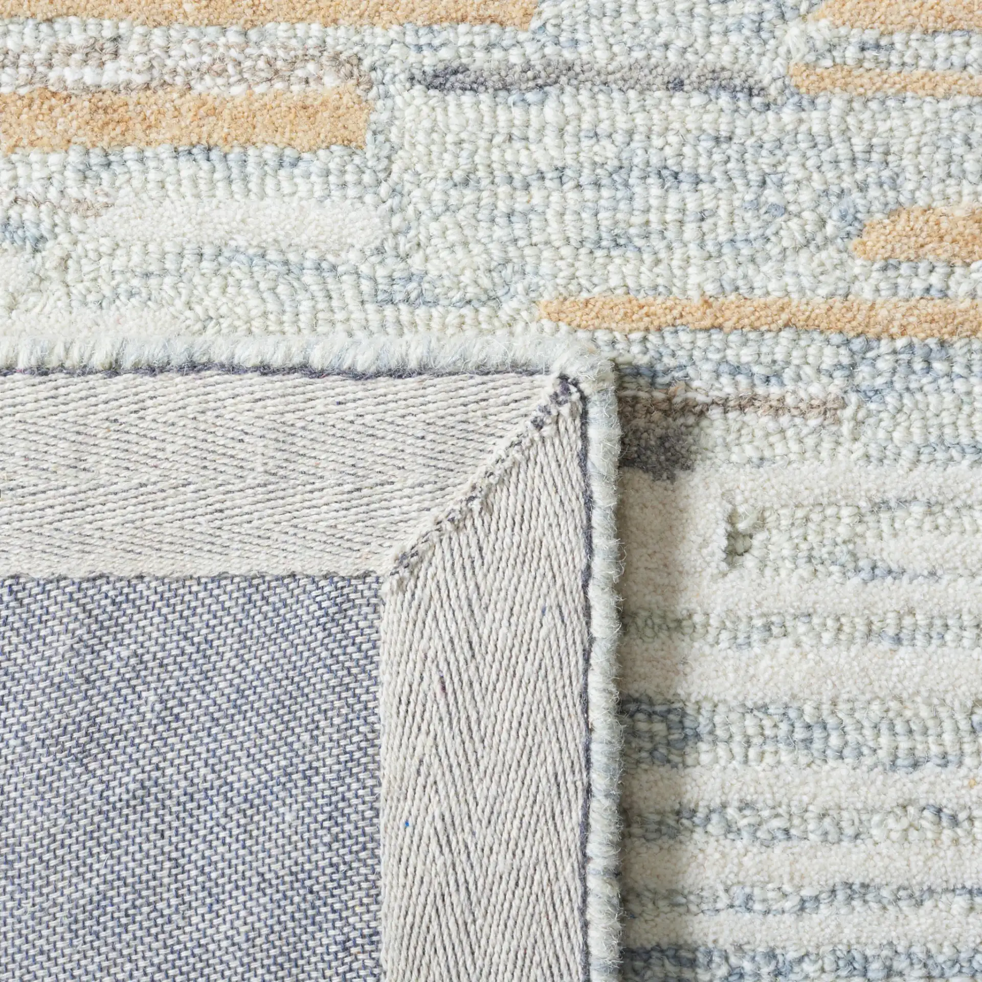 Metro Abstract Striated Hand-Tufted Wool Rug in Natural / Gold in a styled room