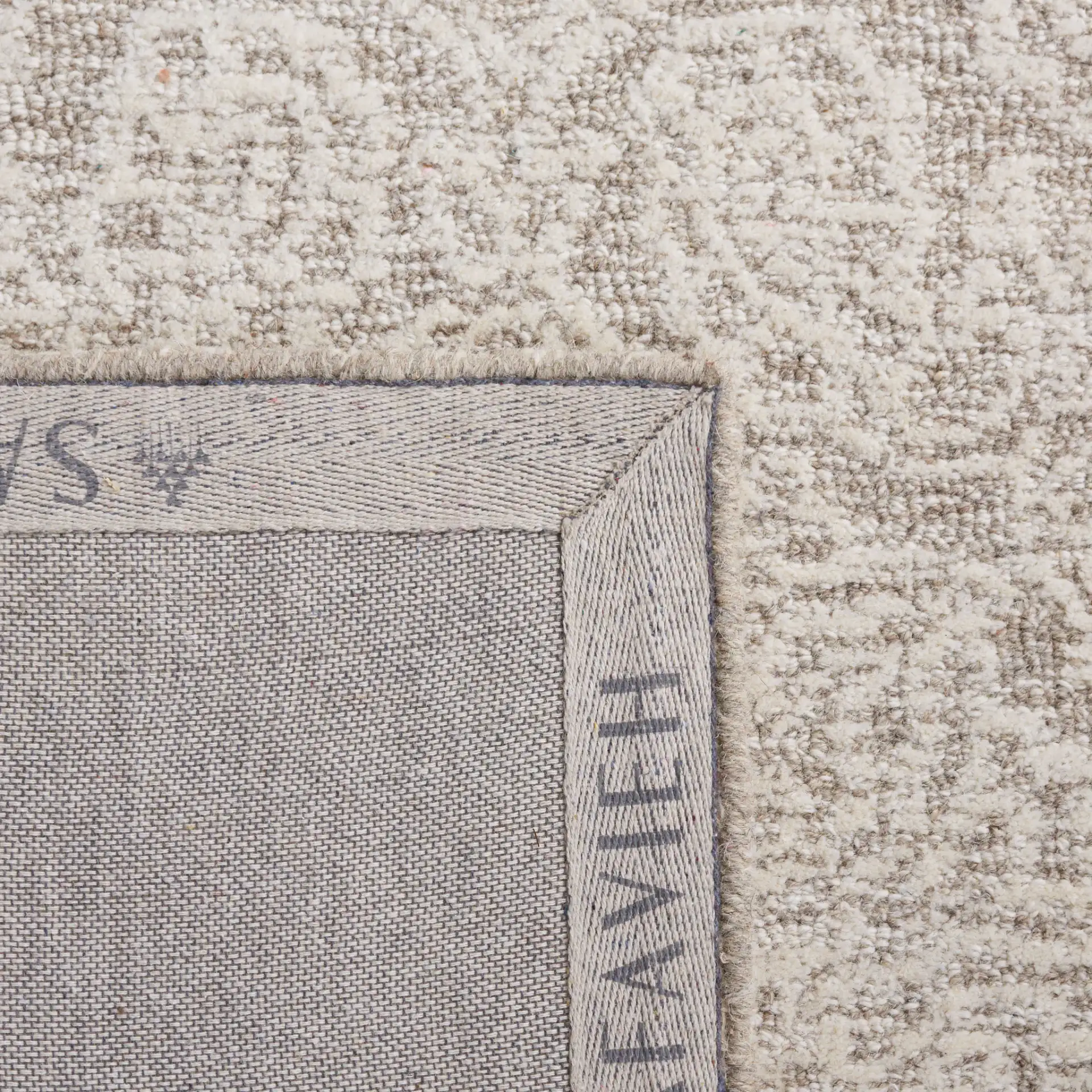 Metro Distressed Damask Hand-Tufted Wool Rug in Natural / Ivory in a styled room