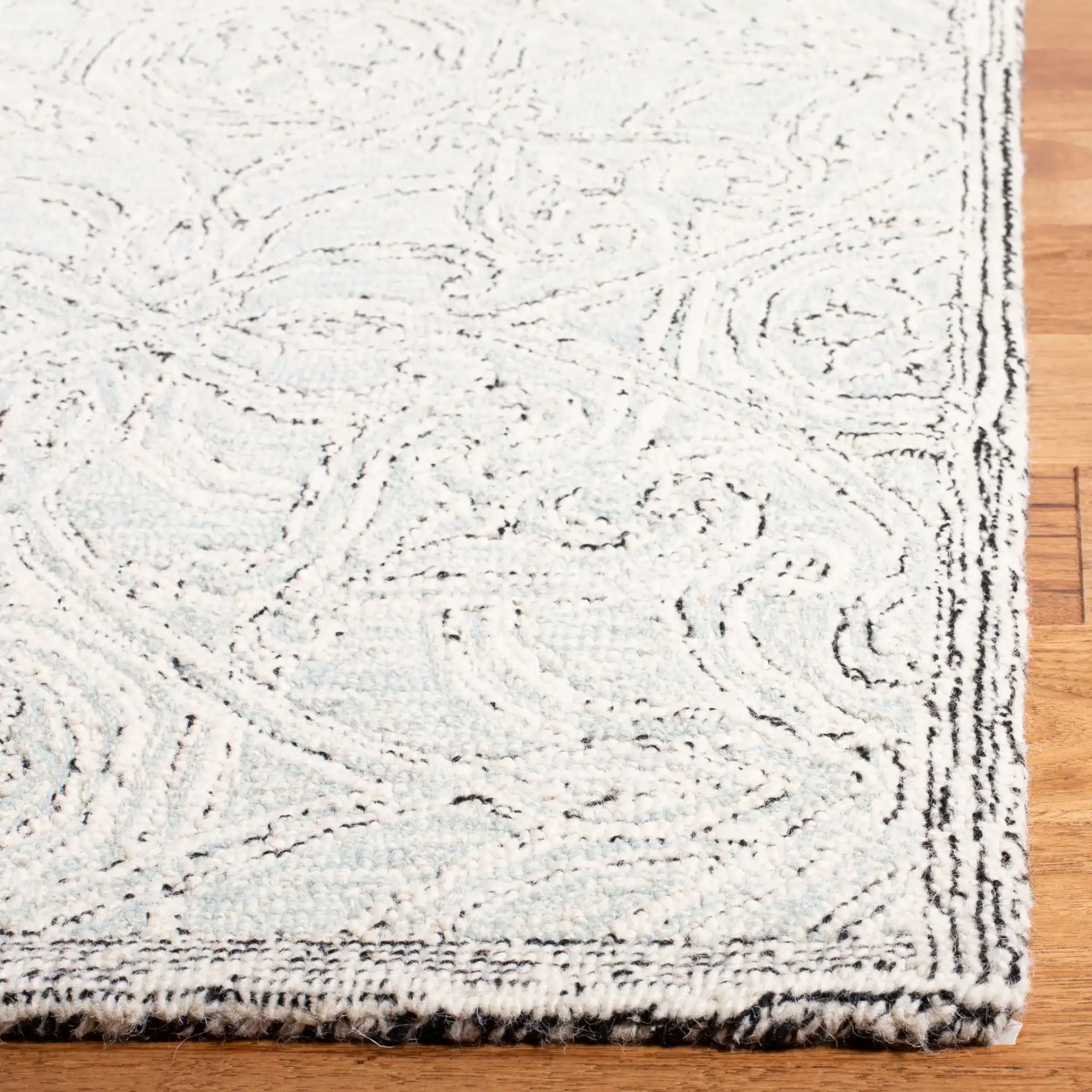 Micro-Loop Arabesque Tile Hand-Tufted Wool Rug in Gray / Ivory in a styled room