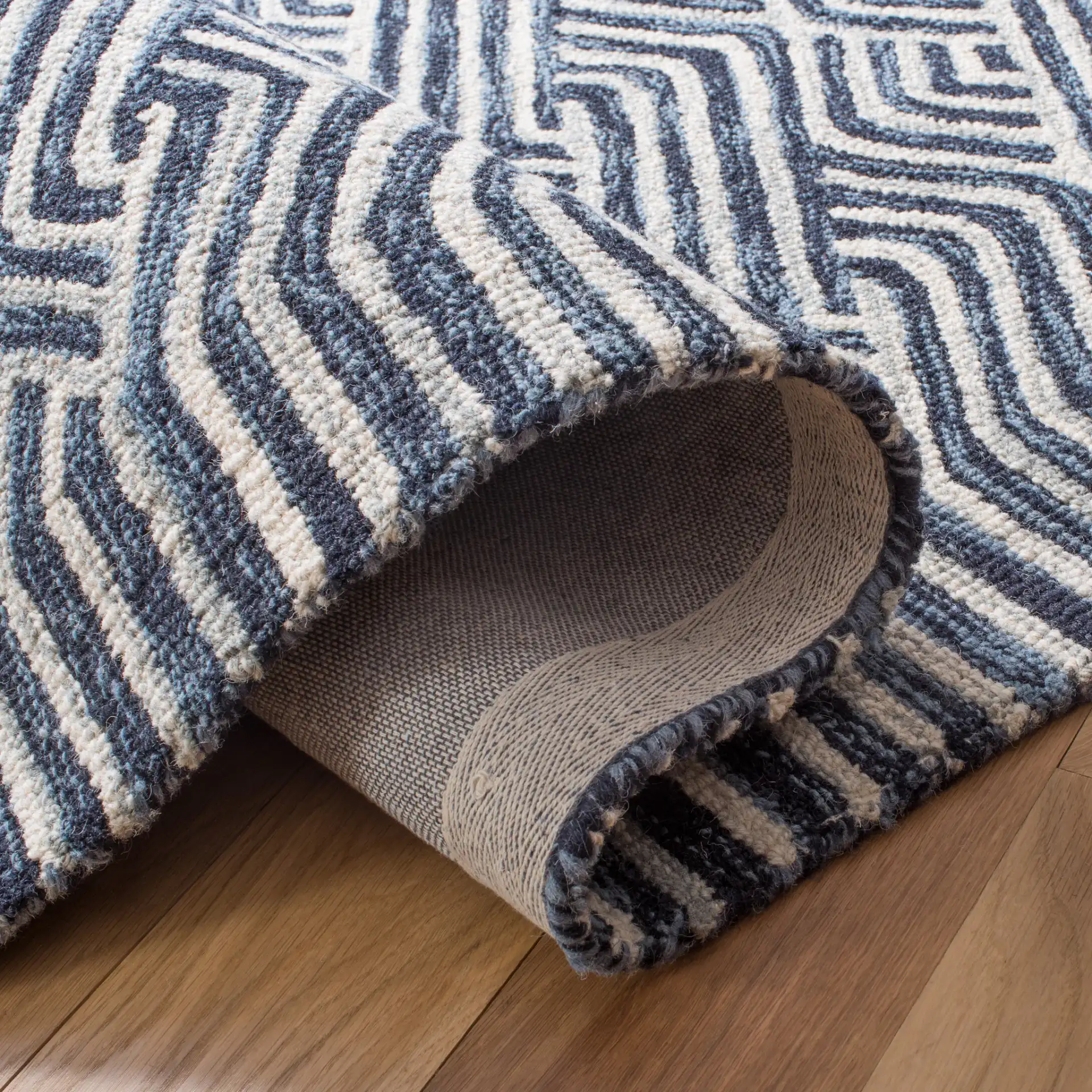 Micro-Loop Chevron Fretwork Hand-Tufted Wool Rug in Dark Blue / Ivory in a styled room