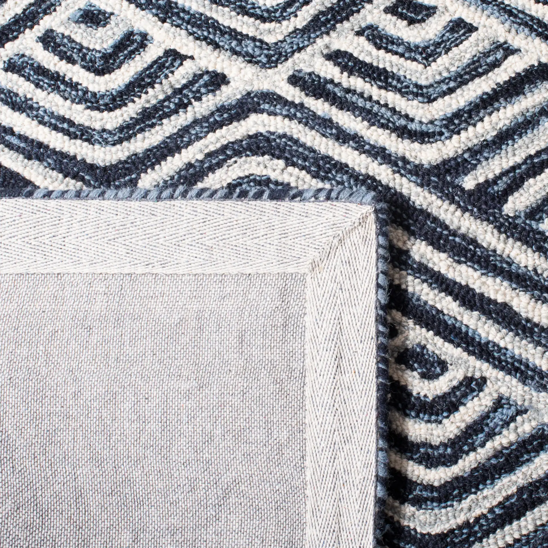 Micro-Loop Chevron Fretwork Hand-Tufted Wool Rug in Dark Blue / Ivory in a styled room